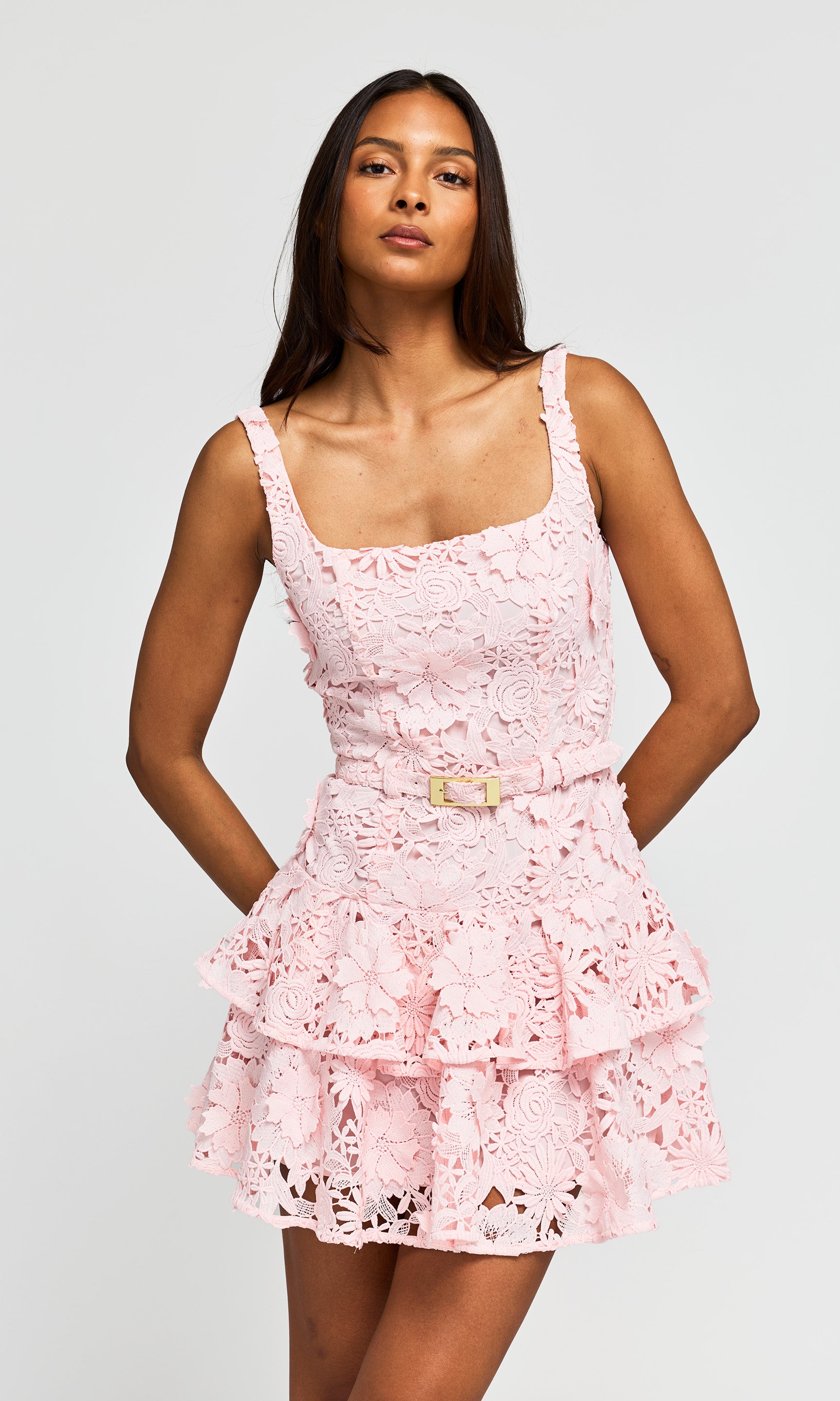 Woman wearing a pink lace dress on a white background