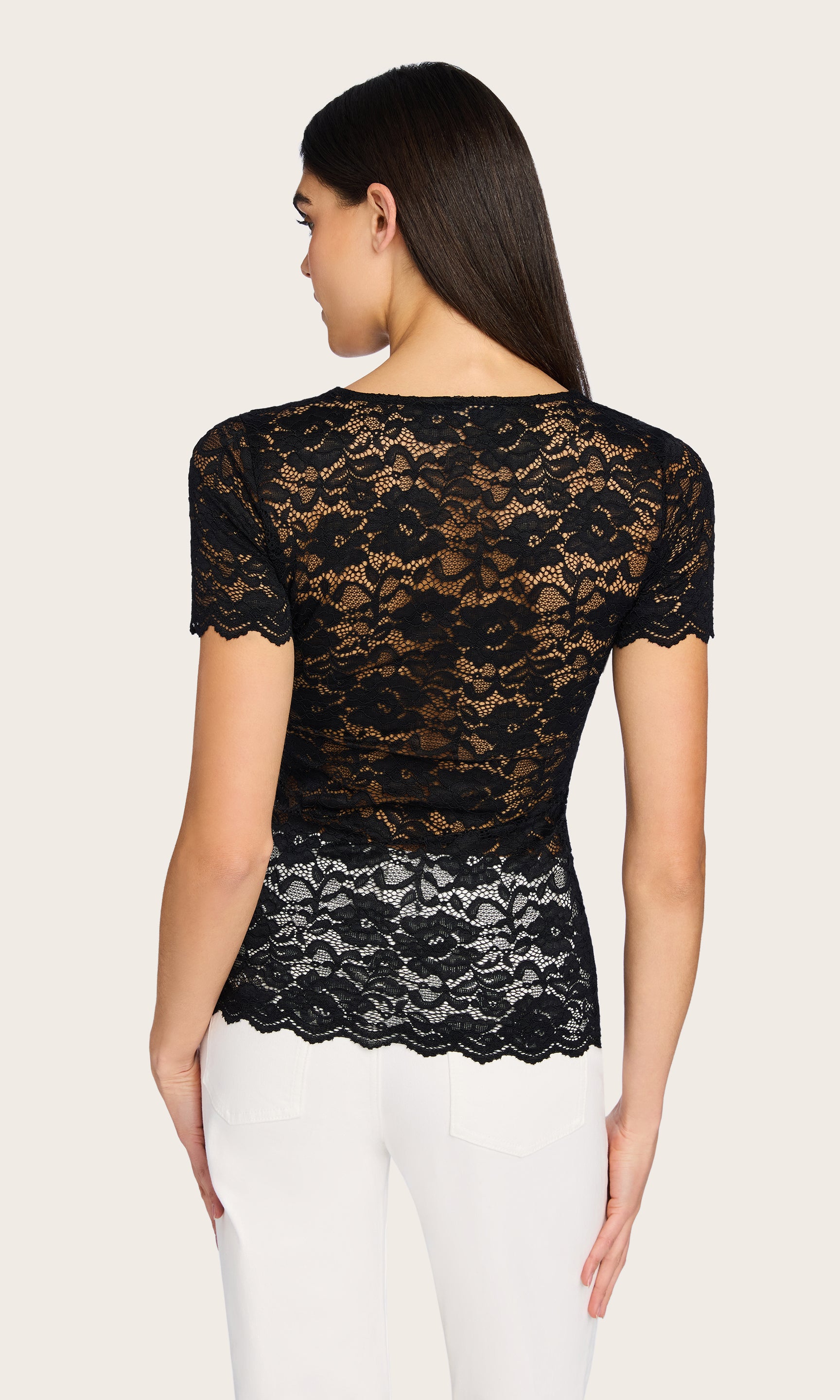 Rear view of the model in the Abigail Lace Top, showcasing the delicate lace pattern and scalloped hem from the back.