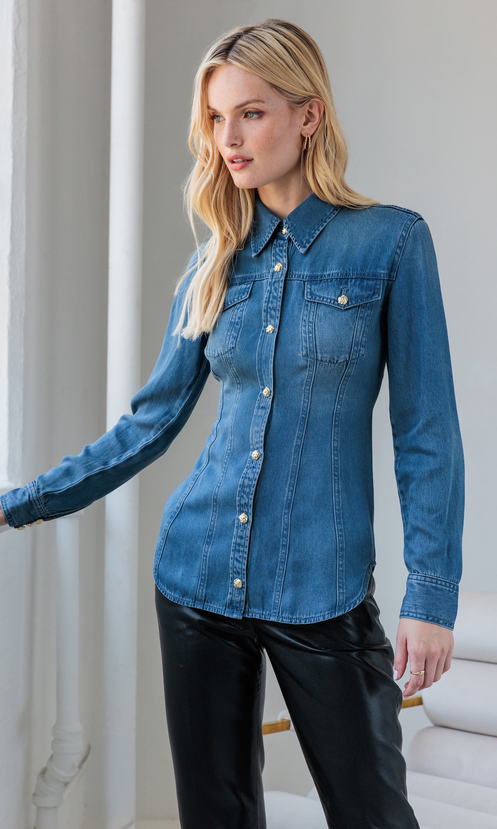 The model stands in a relaxed front view pose wearing the Antoinette Denim Shirt, showcasing its slim fit and button detailing.