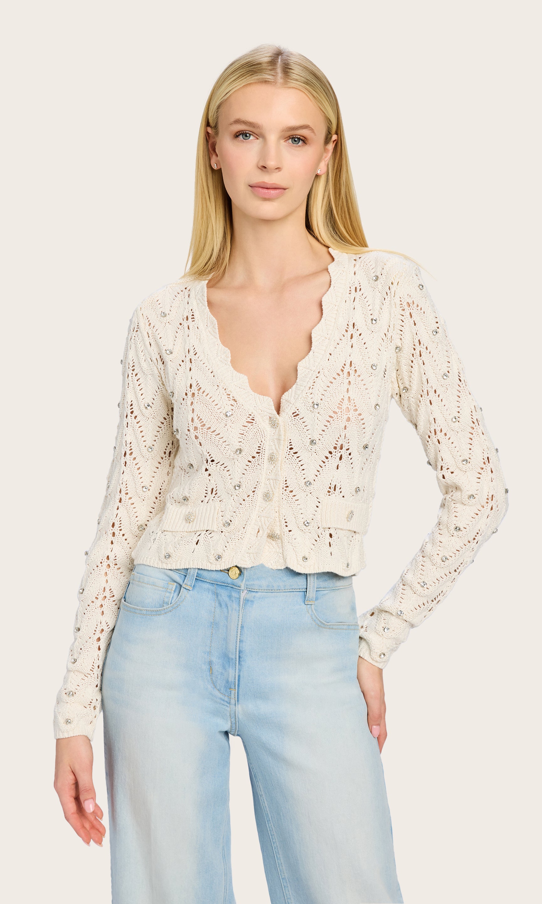 Front-facing shot of the Blake Crystal Pointelle Cardigan styled by the model with light-wash jeans, showcasing its cropped fit and elegant pointelle texture.