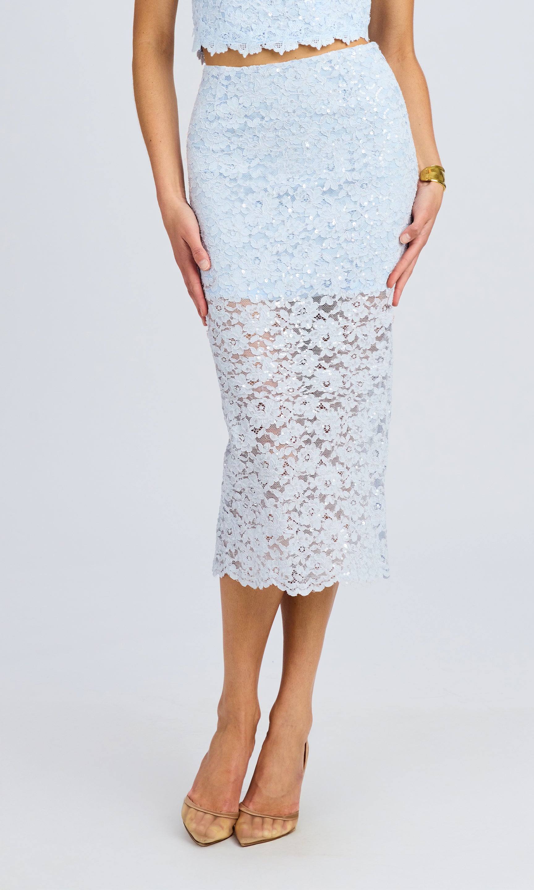 Front view of the model wearing the lace midi skirt, showcasing its fitted silhouette and delicate floral lace design.