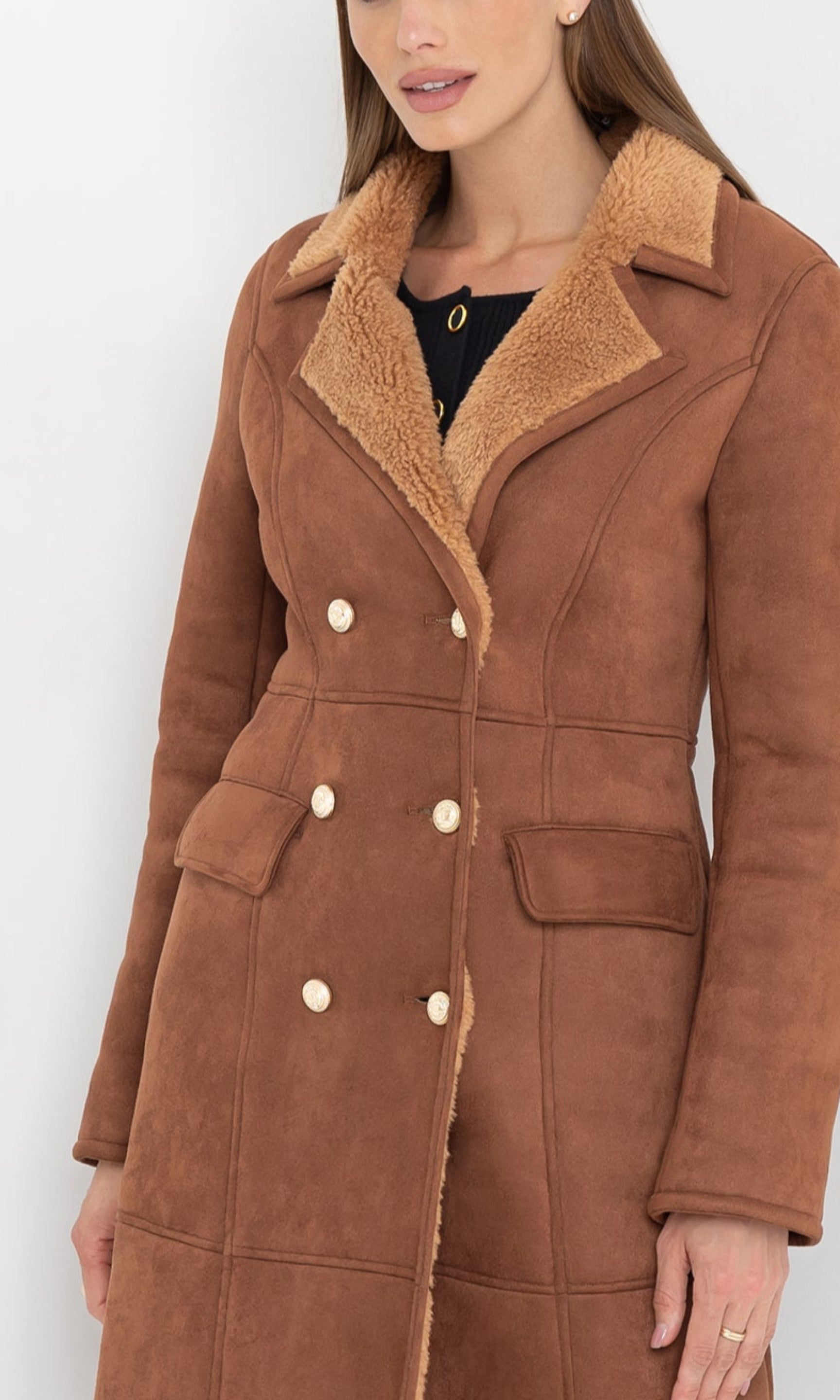 Three-quarter side view of the benton faux shearling coat with pockets.