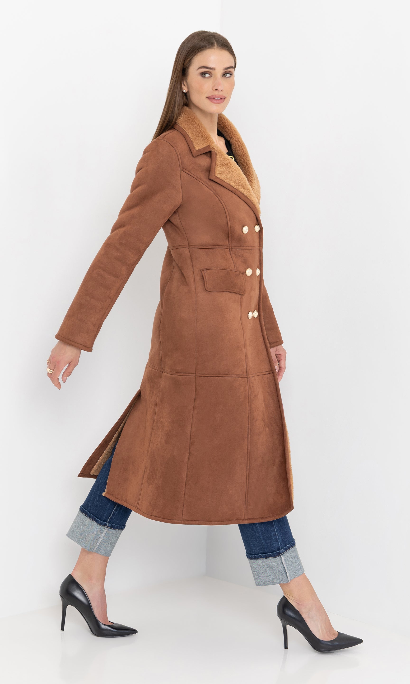 Full body side view of the benton faux shearling coat styled with denim.
