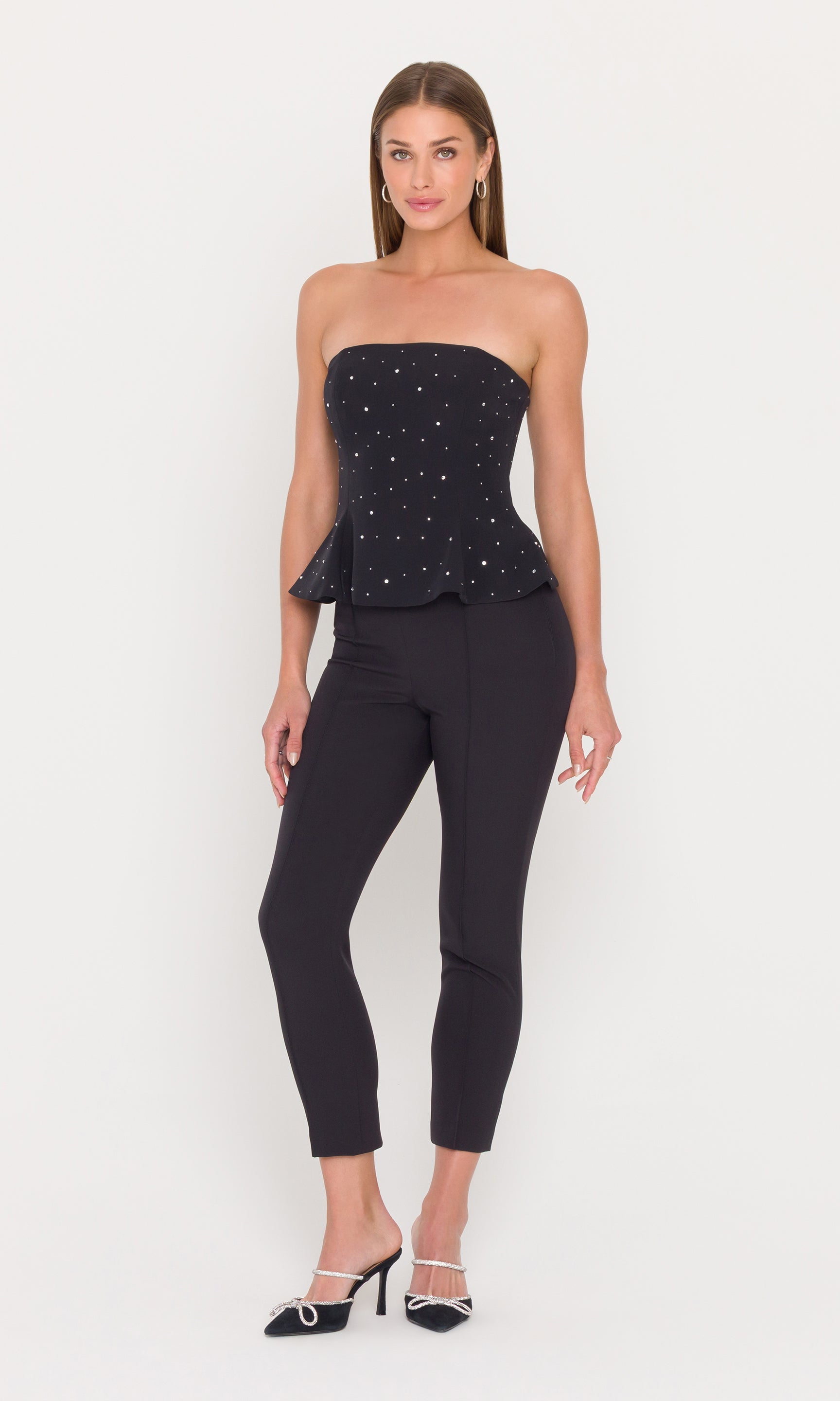 Model wearing a black crystal embellished peplum bustier with black pants