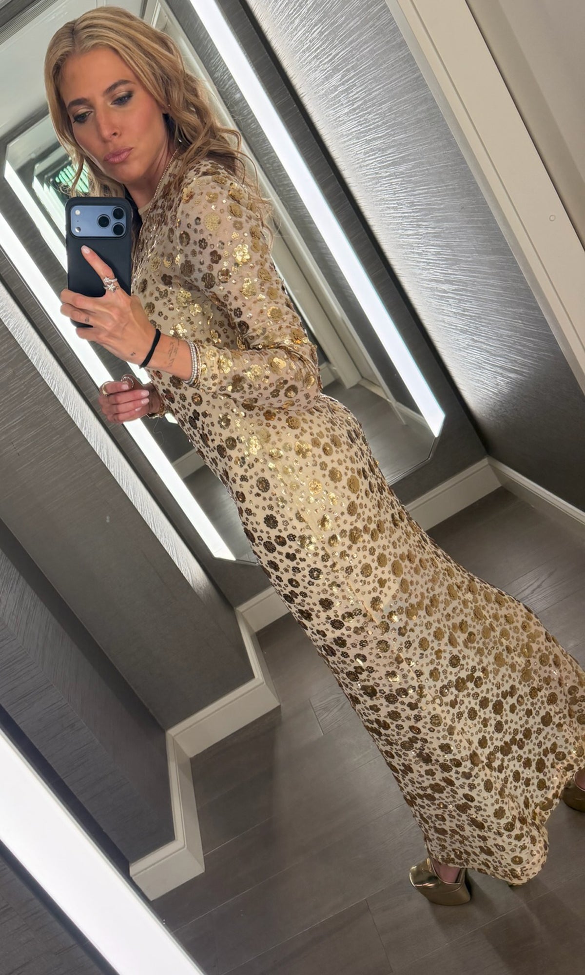 Our founder Roni wearing a beige dress with gold floral sequins embellishments shown from the back.