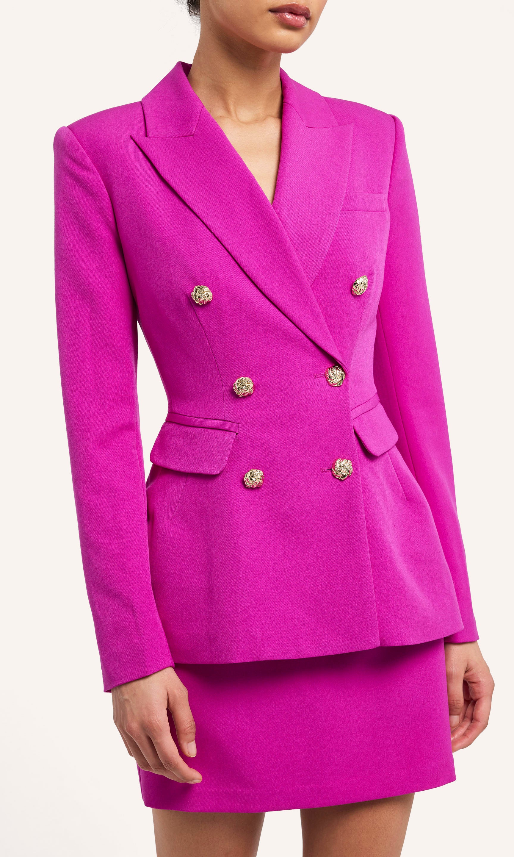 Fuchsia suit with gold buttons on a white background