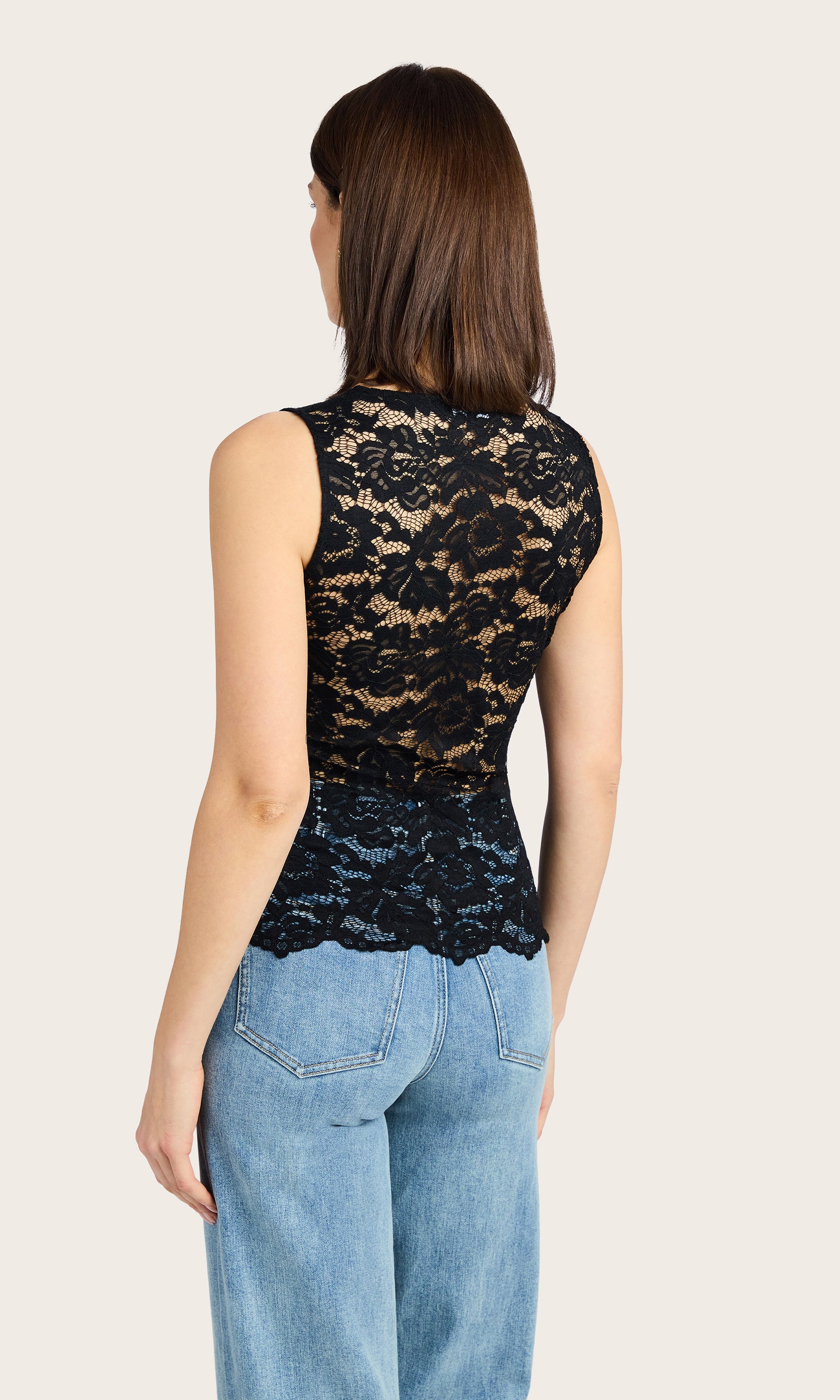 Back view image of model wearing the Brinley lace tank in black paired with blue denim jeans