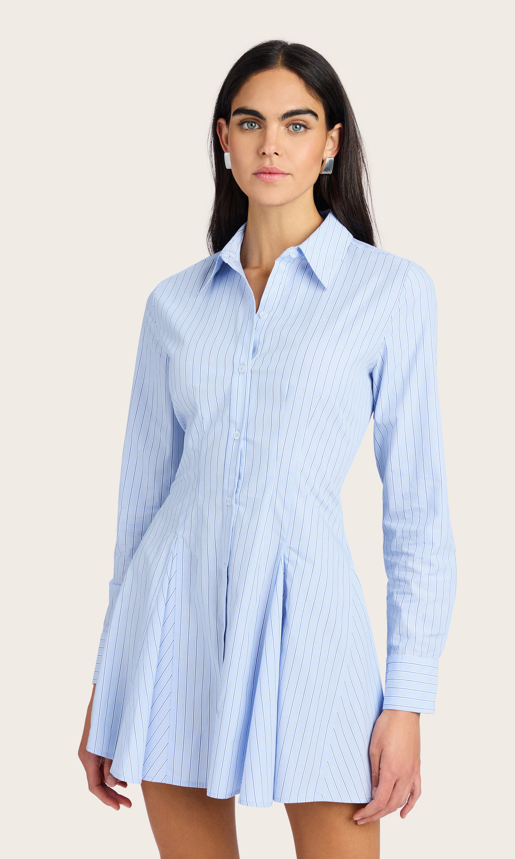 Model wearing the Clemente Pinstripe Poplin Dress with long sleeves, showing the cinched waist and mini skirt silhouette.