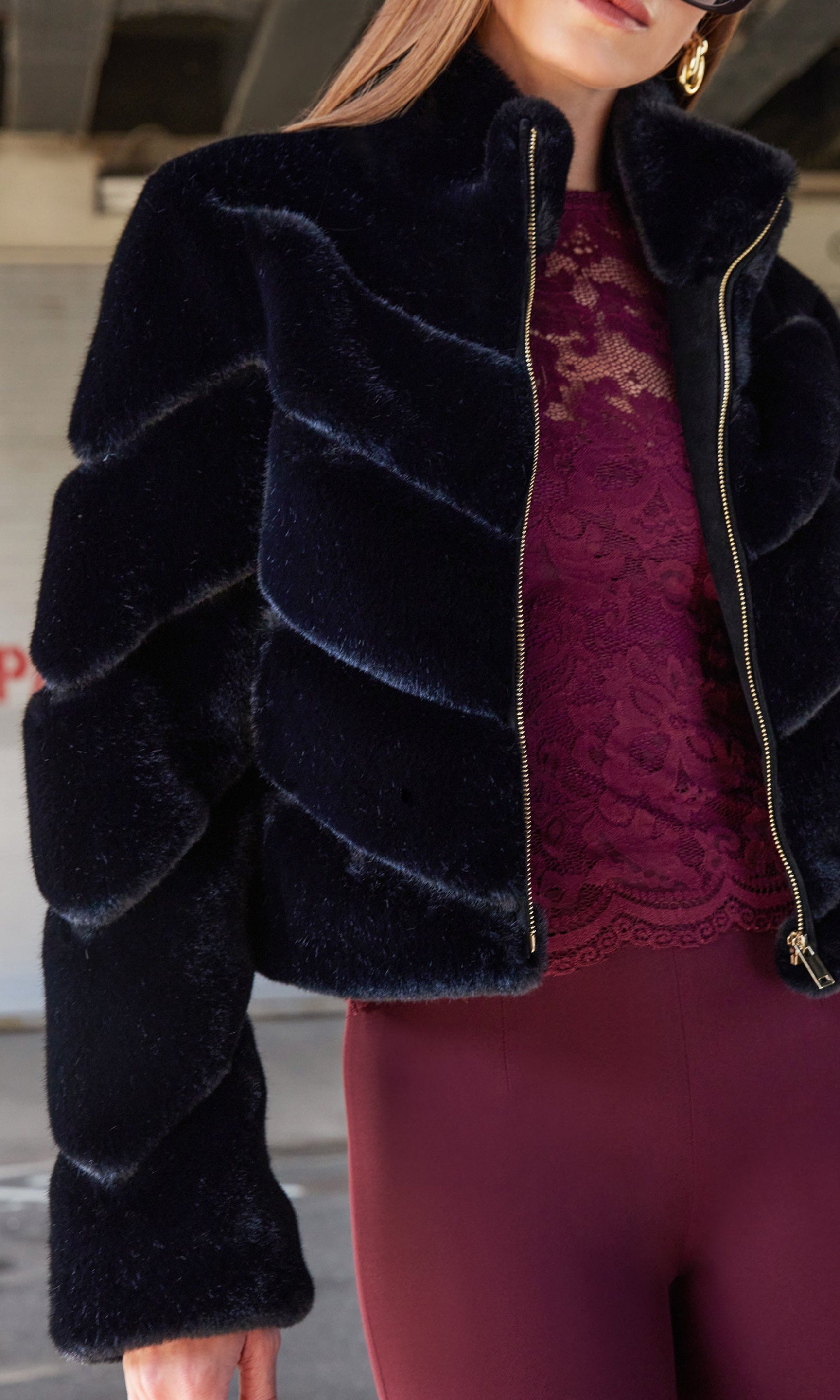 A close-up side view of the model showcasing the Brianna Faux Fur Jacket's soft fur and zipper detail.