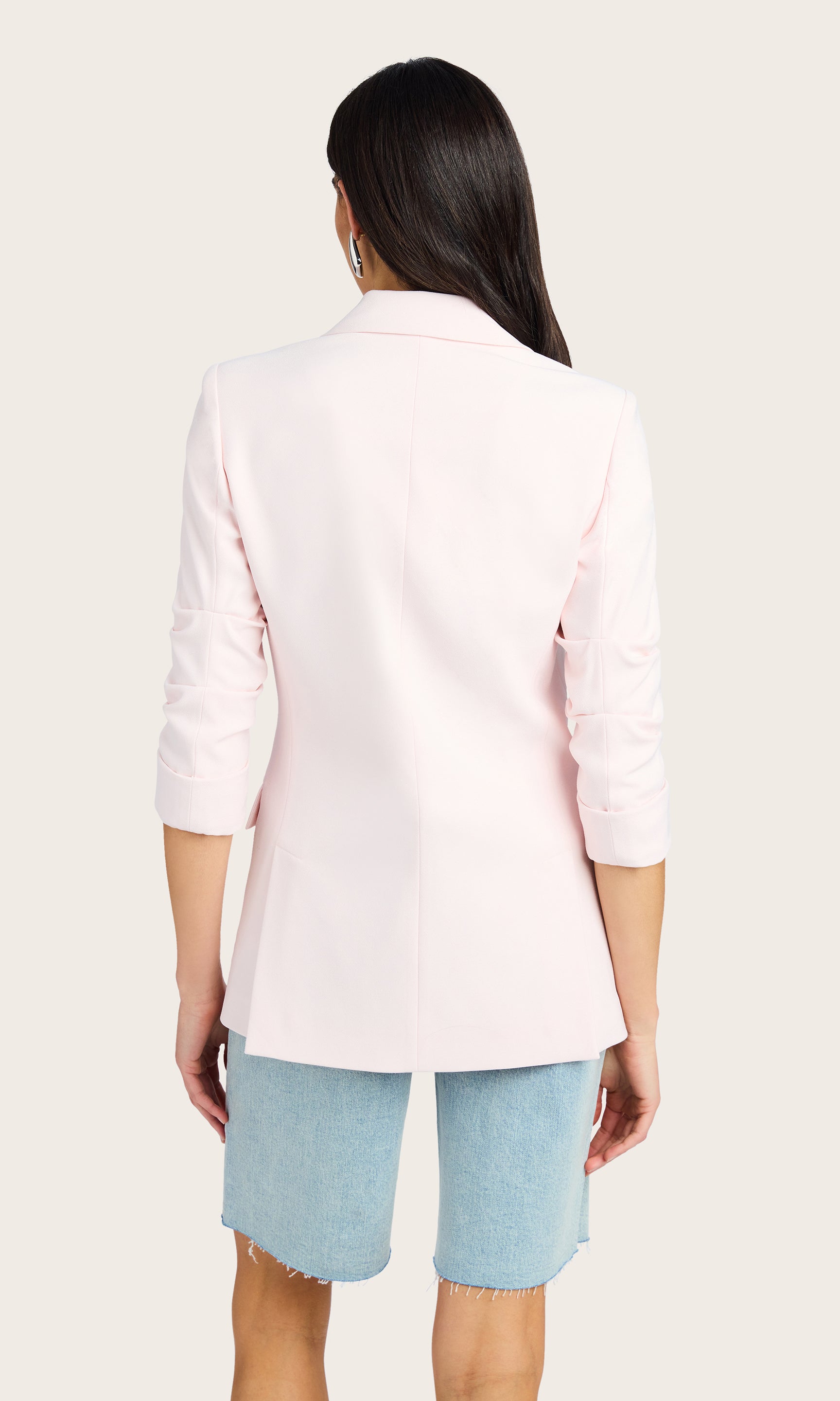 Back view of the model in the Drea Light Weight Crepe Blazer paired with light denim shorts and a white top.