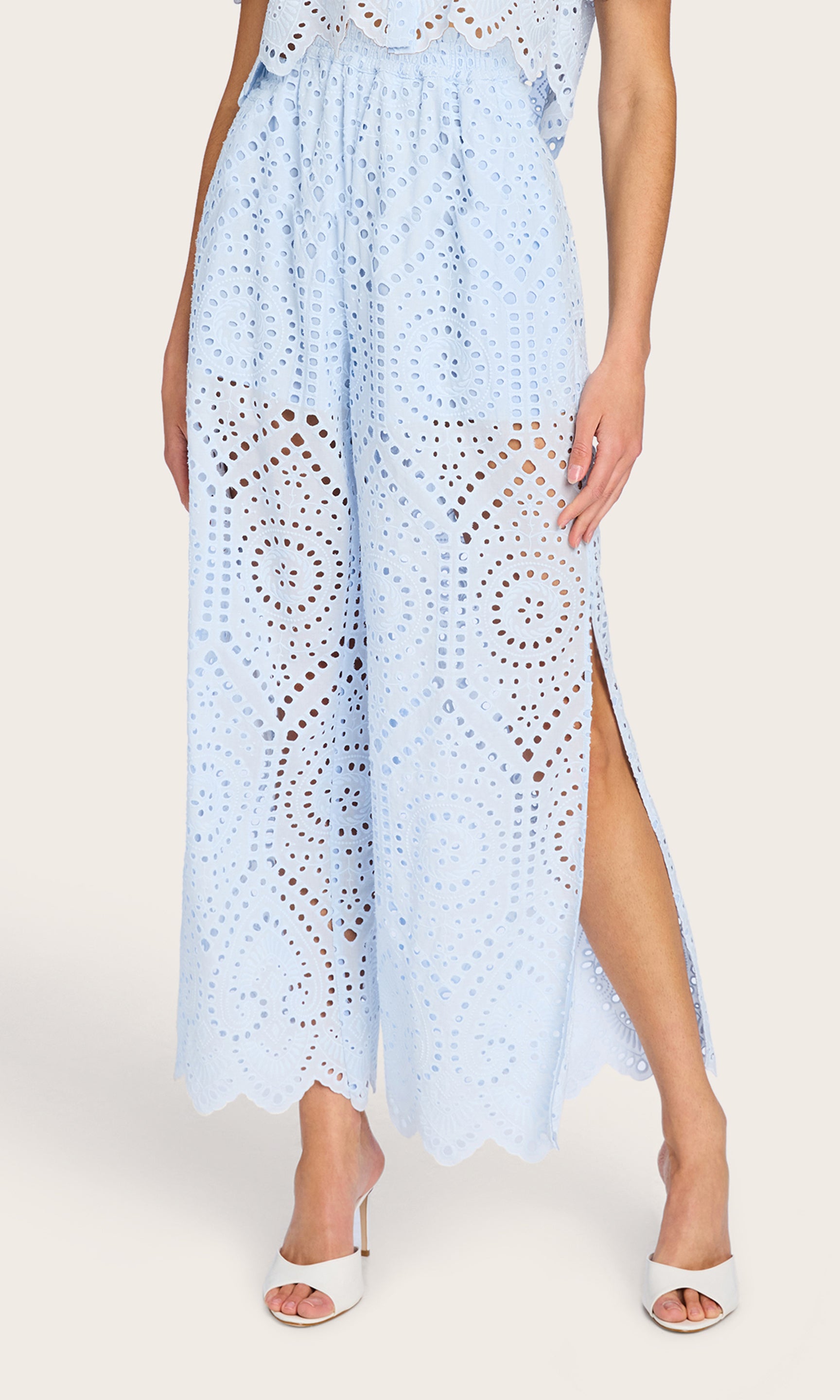 Front view of the model in the Connie Cotton Eyelet Pants in opal, featuring the intricate eyelet pattern and side leg slit.