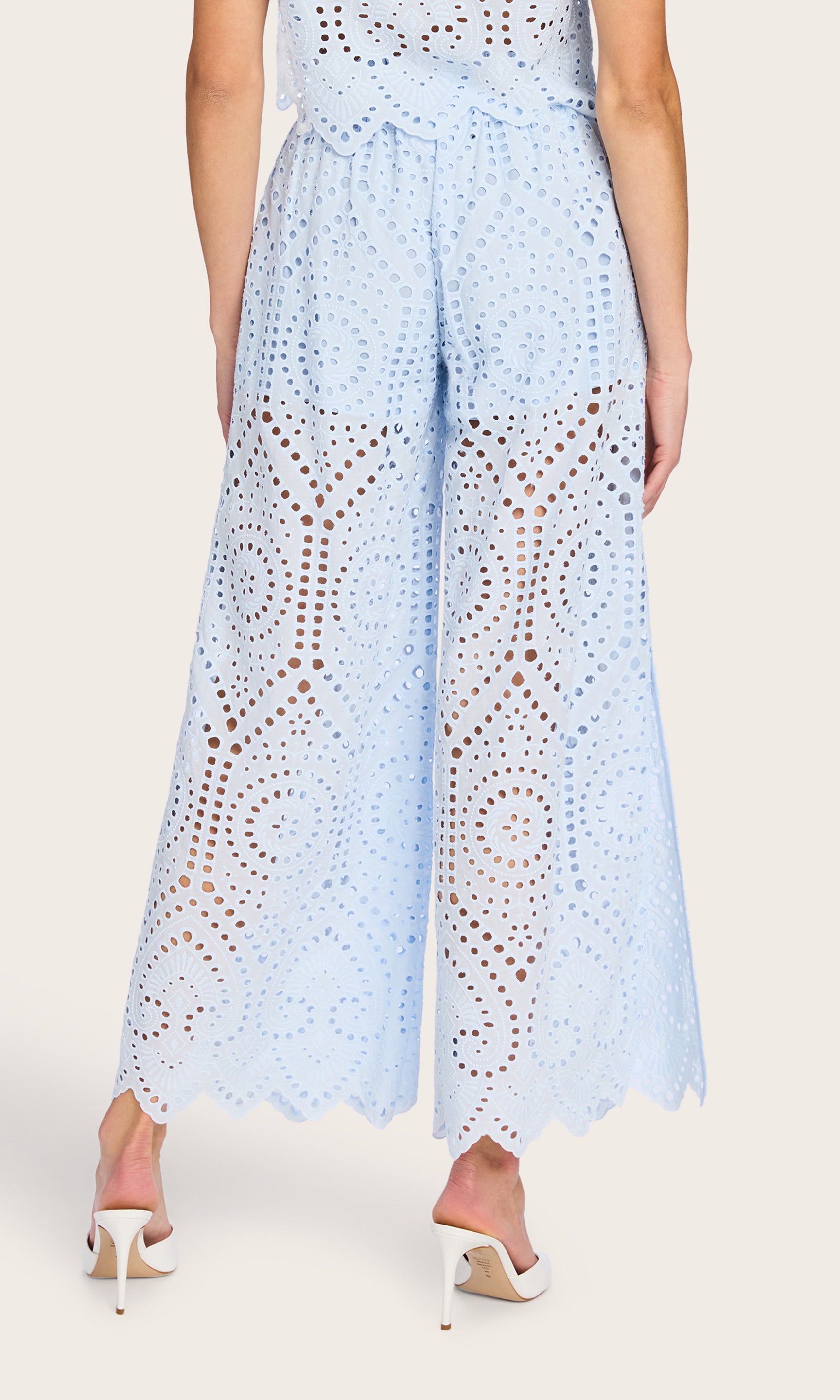 Rear view of the model in the Connie Cotton Eyelet Pants in opal, featuring the intricate eyelet pattern.