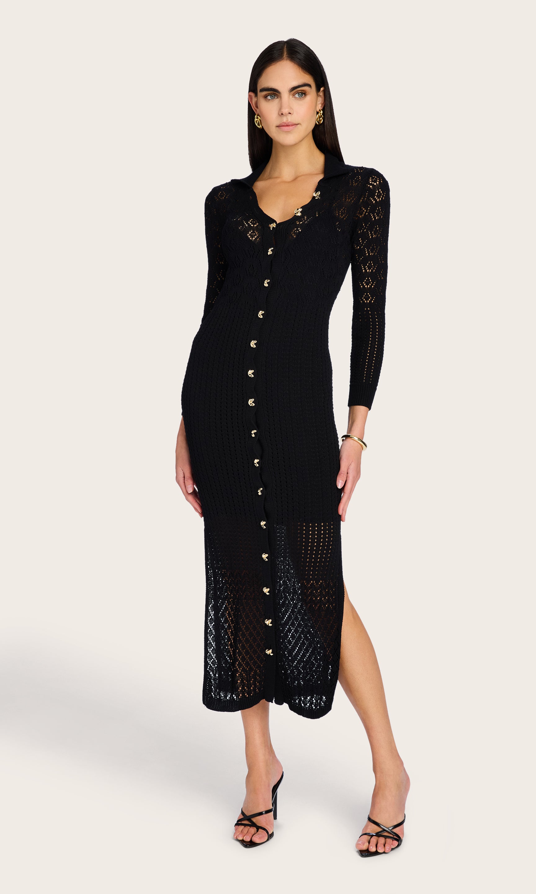Full body view of the model wearing the Eleni Pointelle Knit Dress, showcasing the slim fit silhouette and button-down front styled with soft waves and heels.