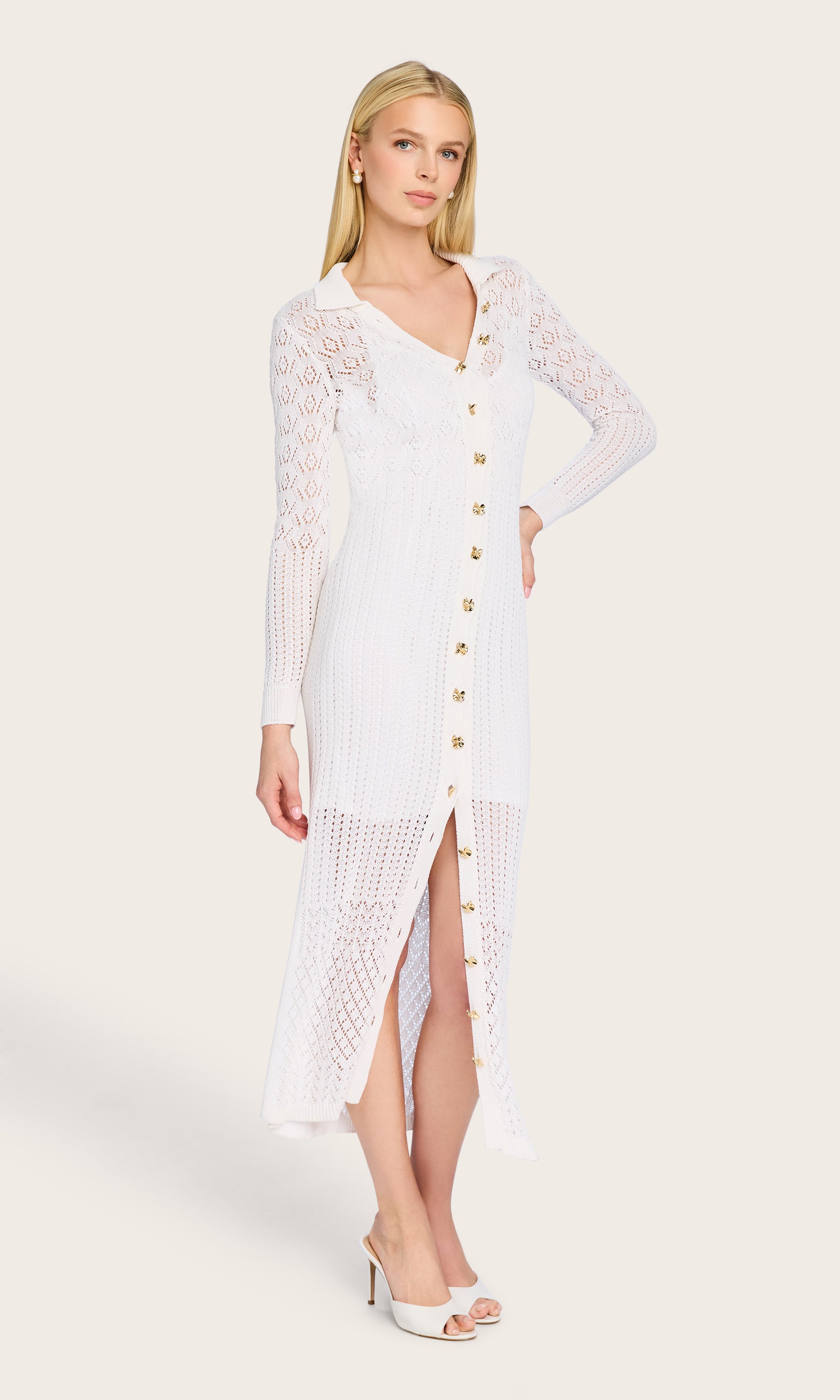 Full body front view of the model wearing the Eleni Pointelle Knit Dress, styled with heels and soft waves, highlighting the slit hem and elegant silhouette.