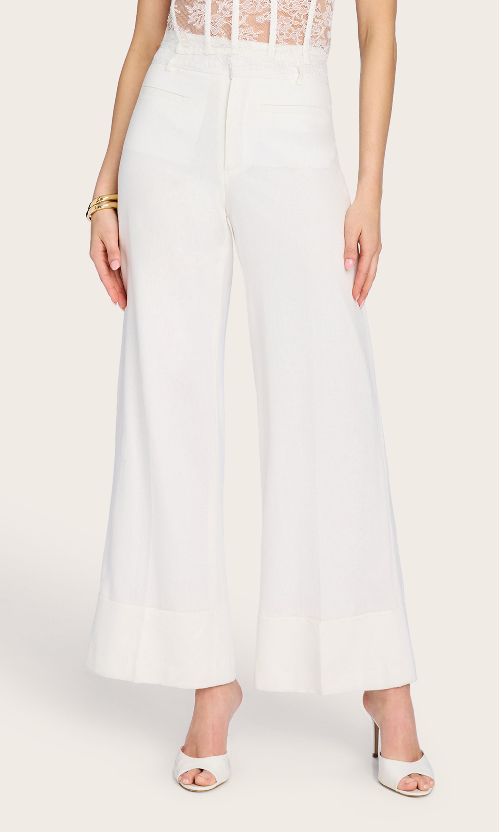 Front-facing view of the Raquel Linen Pants styled with a lace bustier, emphasizing the flattering high-waist fit and ankle-length cut.