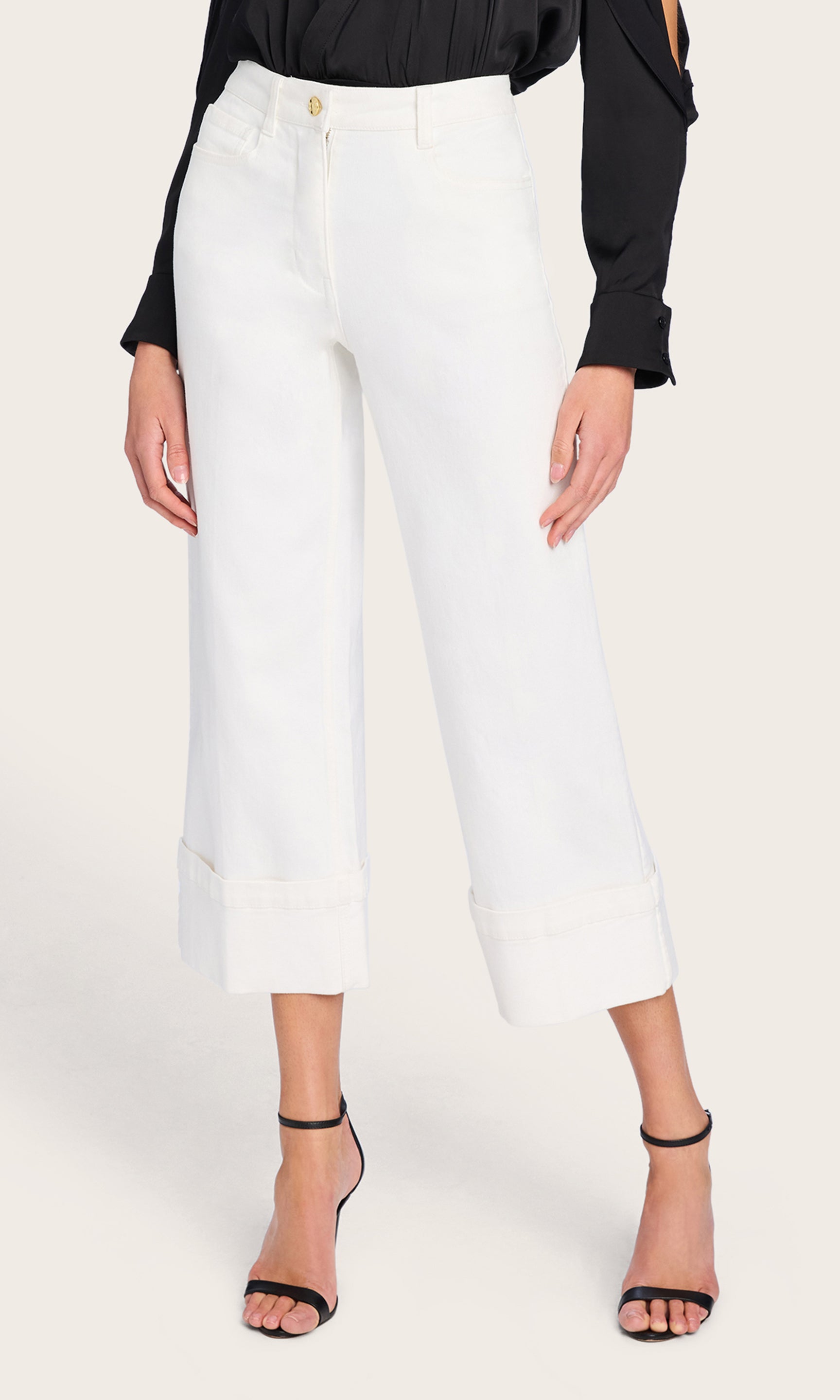 The model showcases the Eros Denim Pant in a straight-on front view, drawing attention to its clean silhouette, crisp white wash, and wide-leg shape.