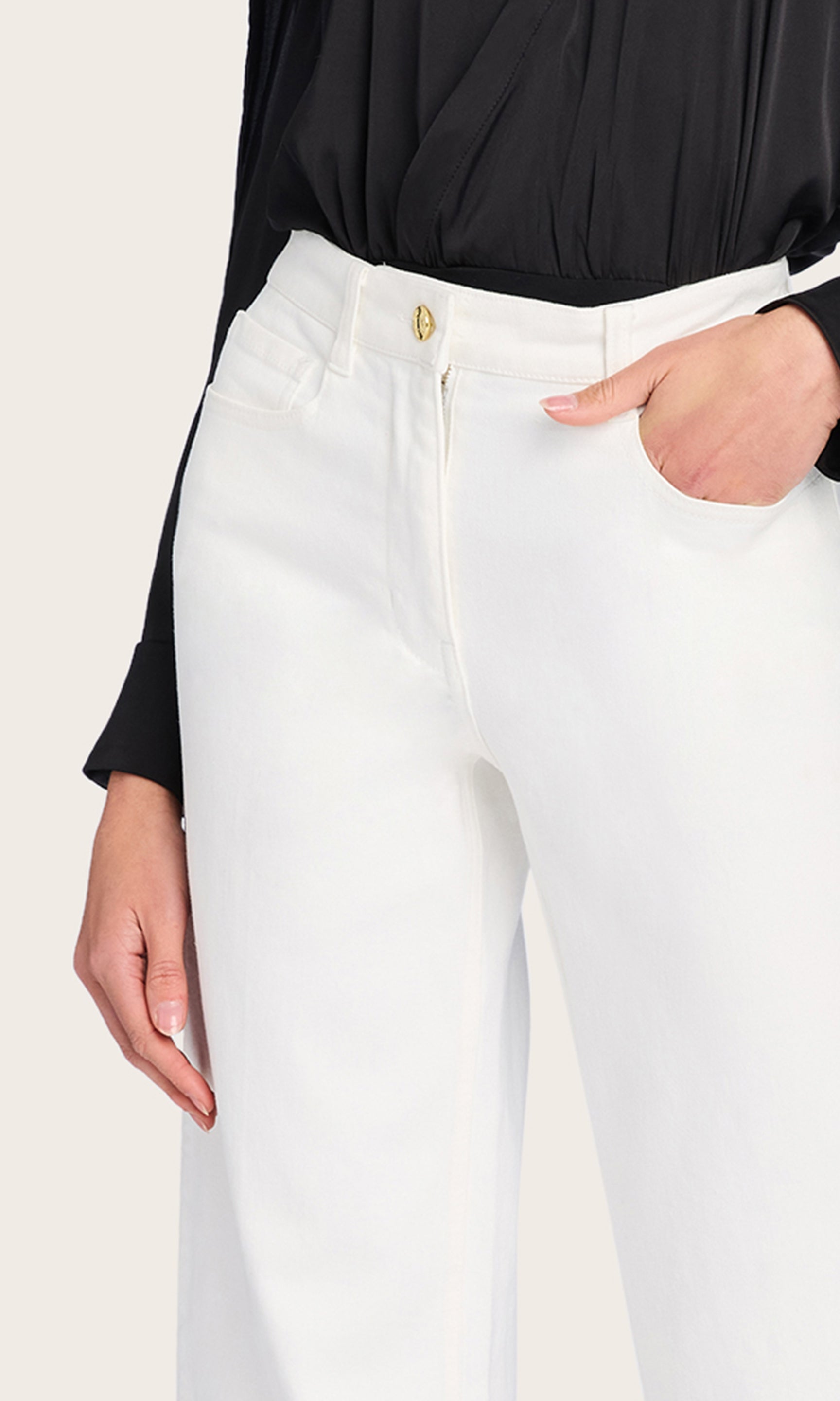 A close-up view of the model in the Eros Denim Pant highlights the polished waistband, structured pockets, and double-button closure.