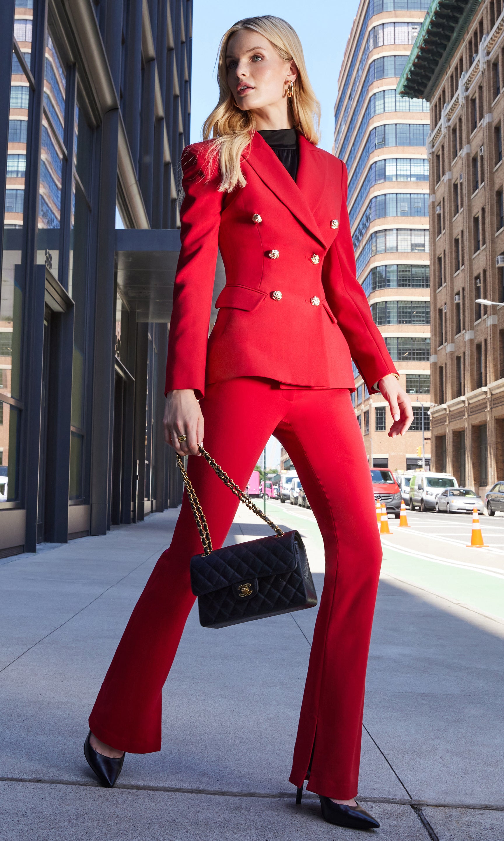 Woman in a red suit walking on a city street