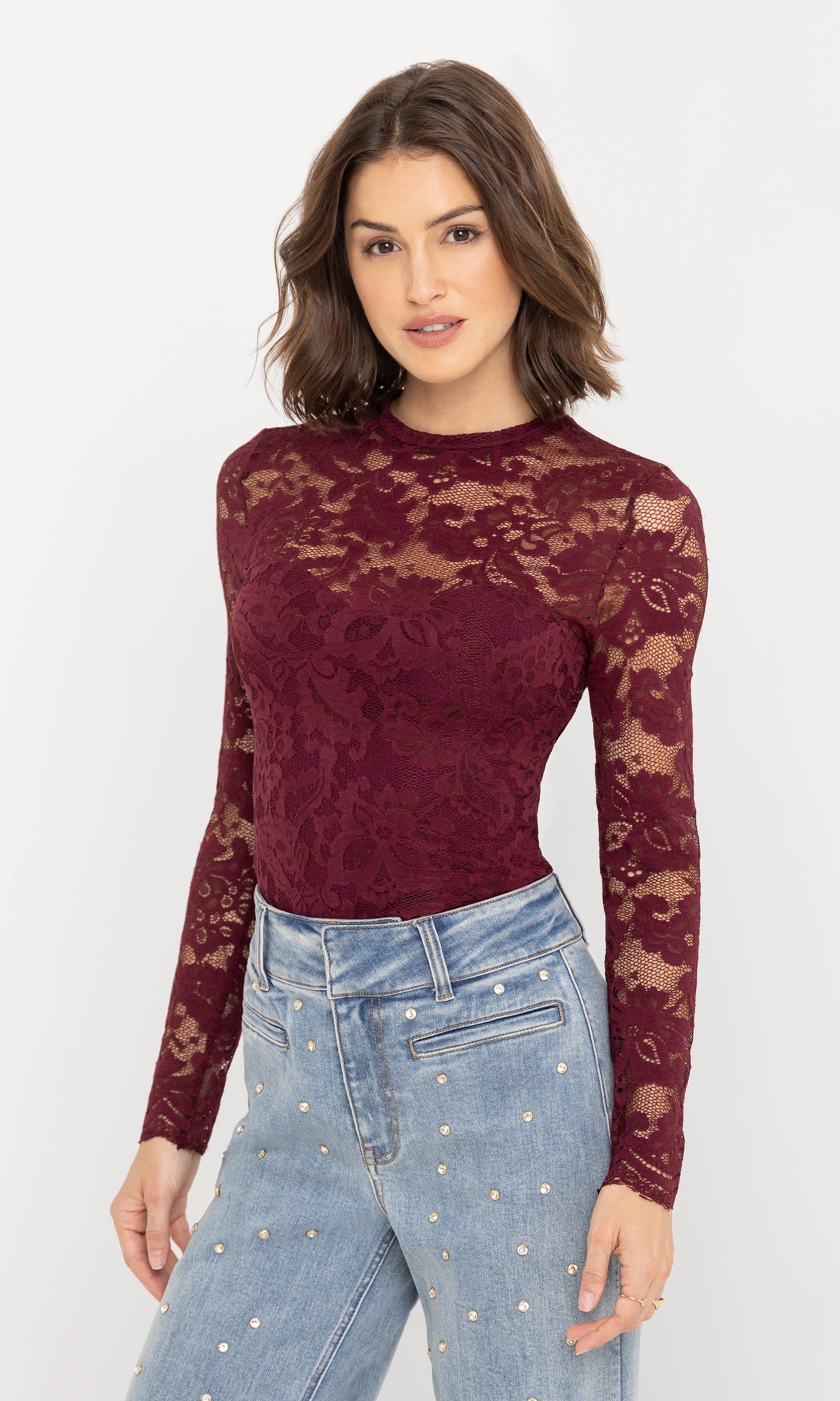 Angled front view of the Clayton Lace Top in burgundy, emphasizing the semi-sheer lace sleeves and fitted bodice.