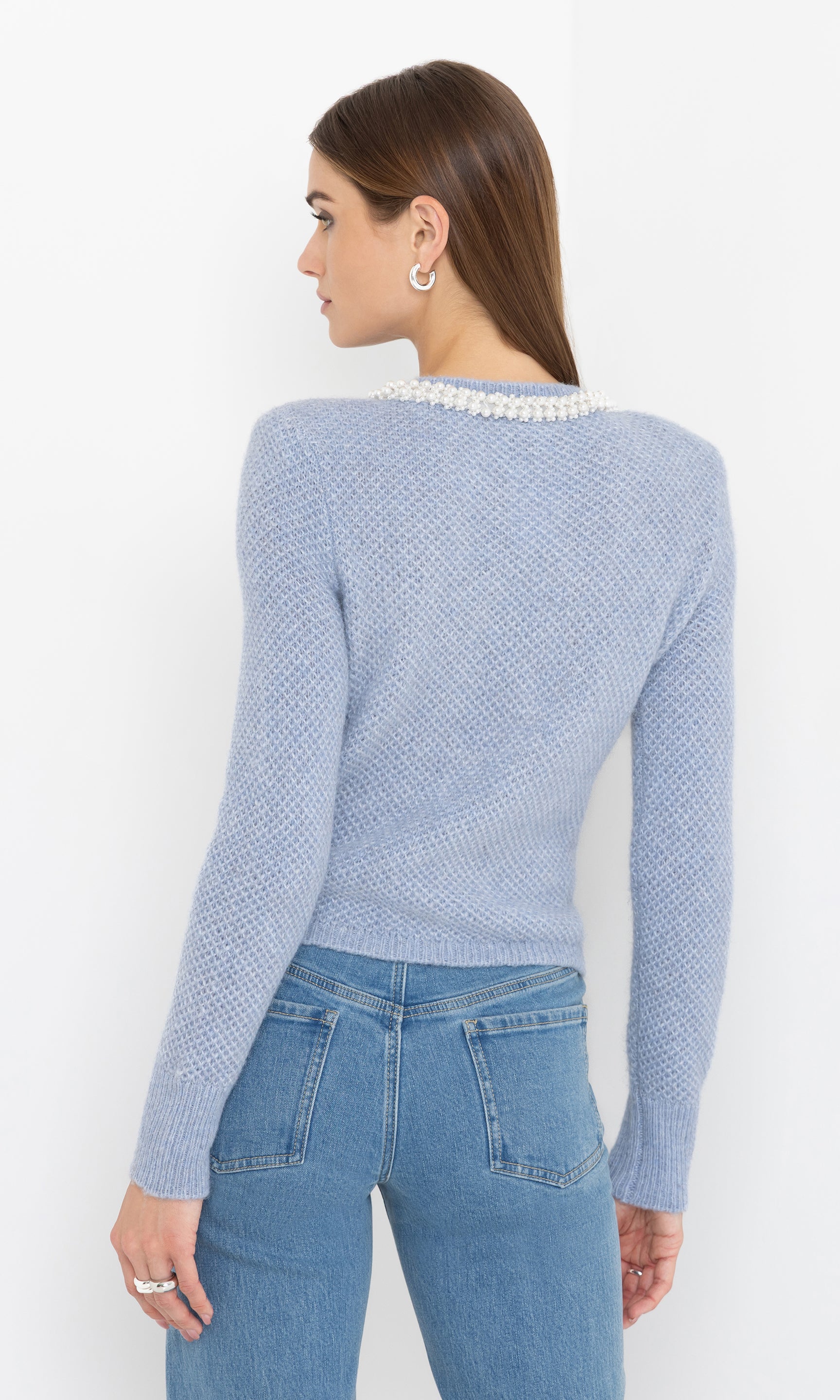 Rear view of the Clove Cardigan in soft blue, highlighting its classic fit and pearl trim hem.