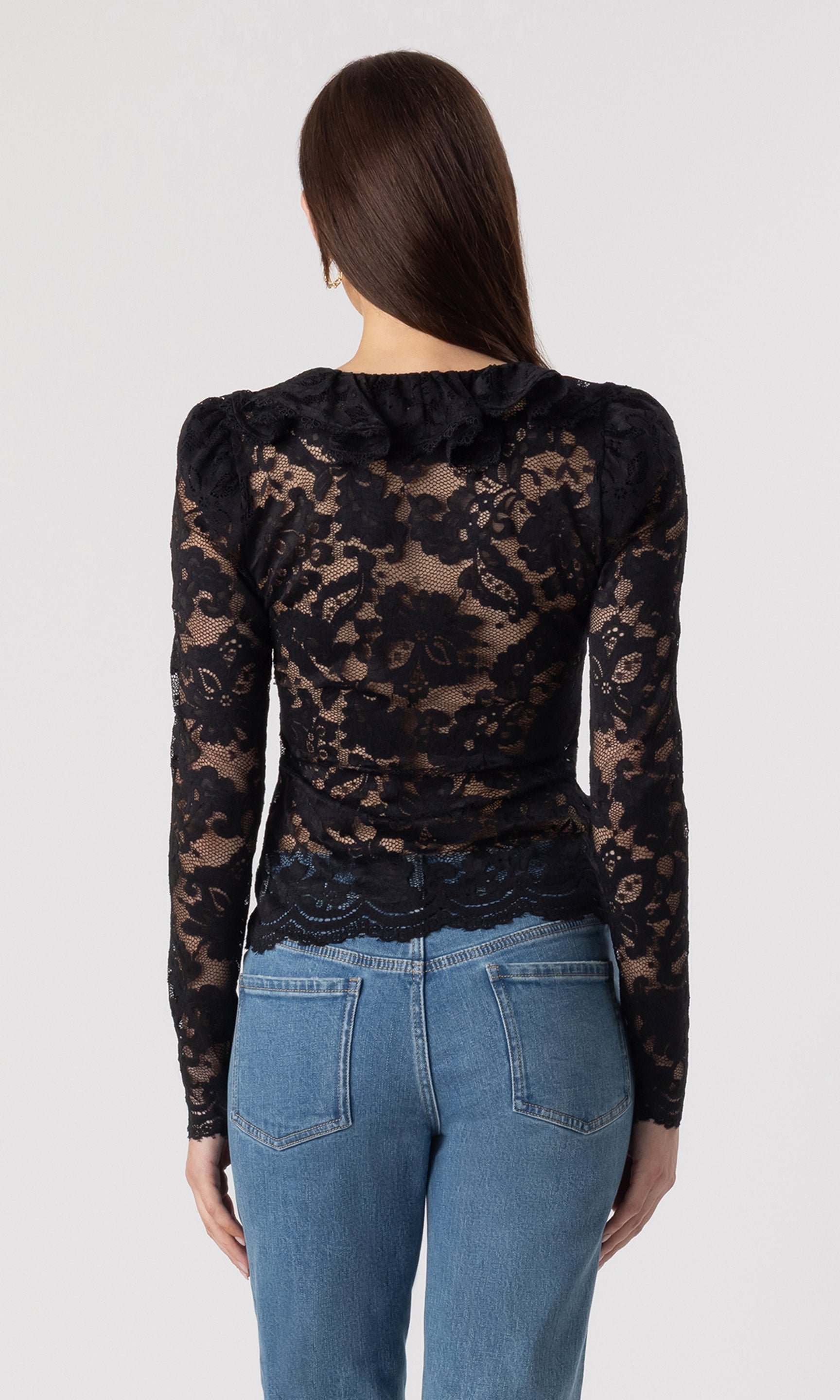 back view image of model wearing the black Corsa lace blouse paired with blue jeans