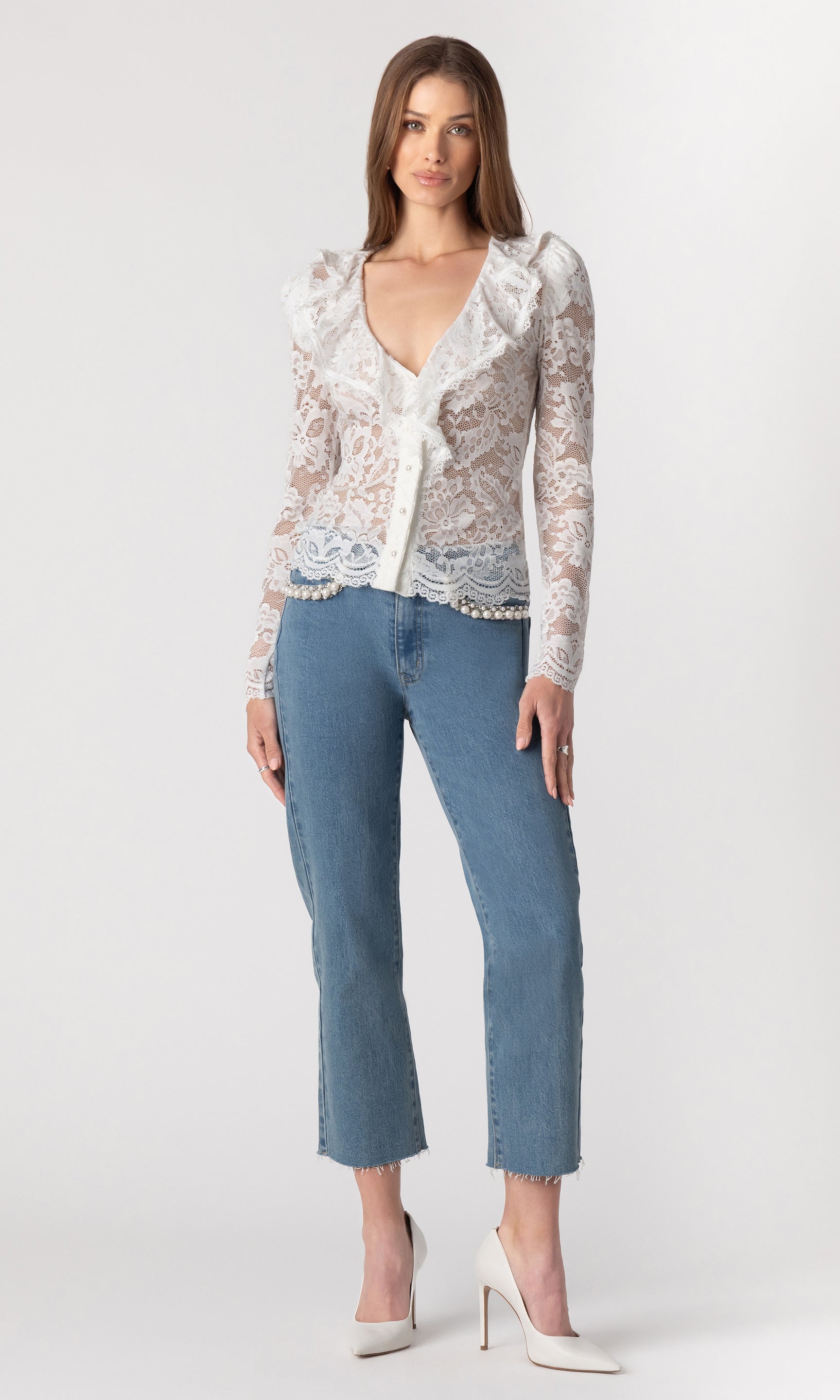 full body image of model wearing the Corsa lace top in white paired with blue jeans and white heels