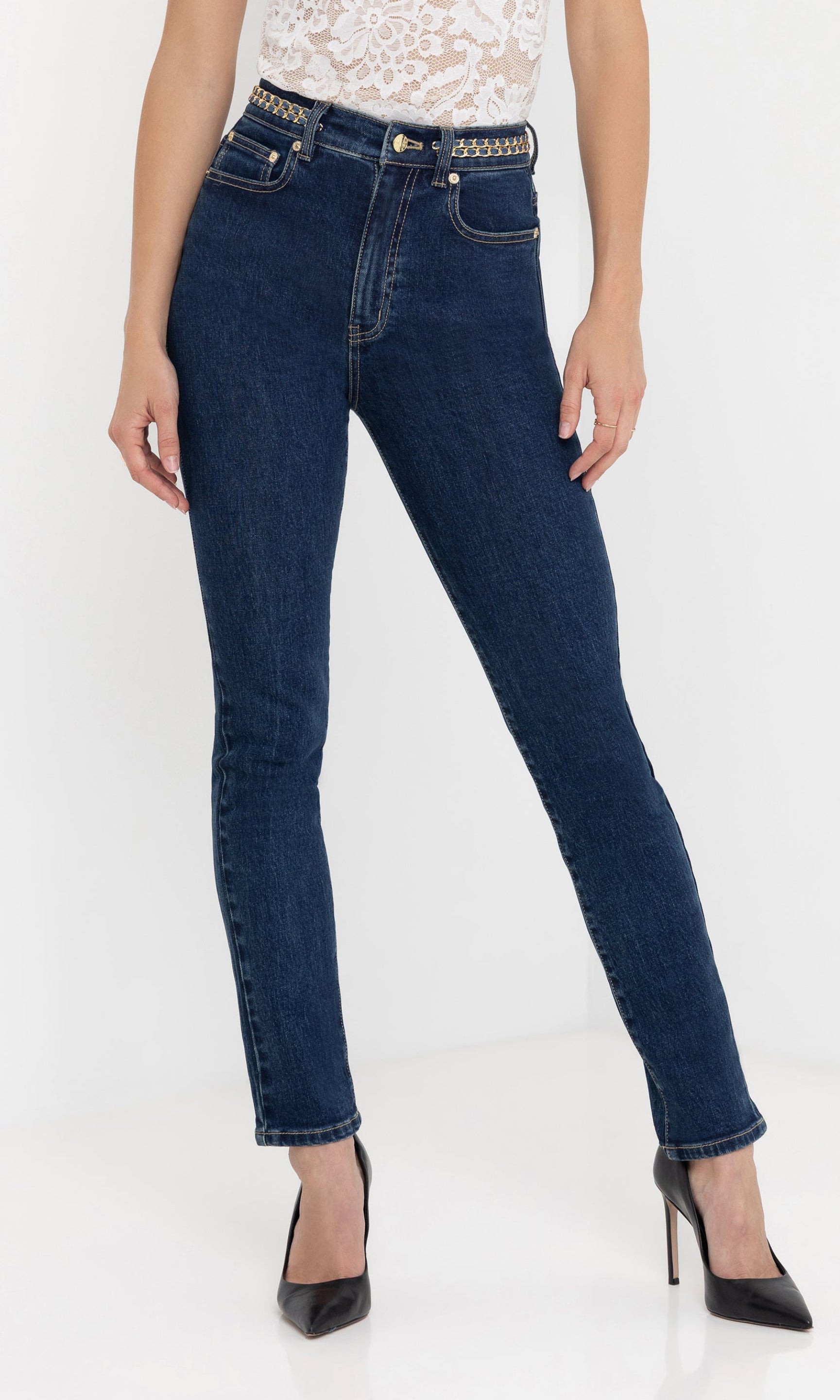 Front view of the Darren Denim Pants paired with a white lace top and black heels, highlighting the slim-fit silhouette.