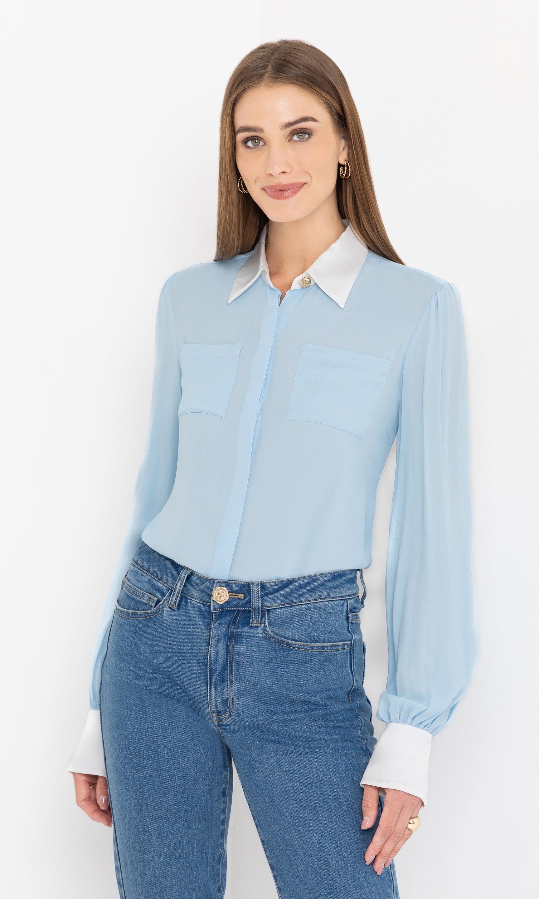 Full front view of the blouse styled with blue denim jeans for a chic casual look.