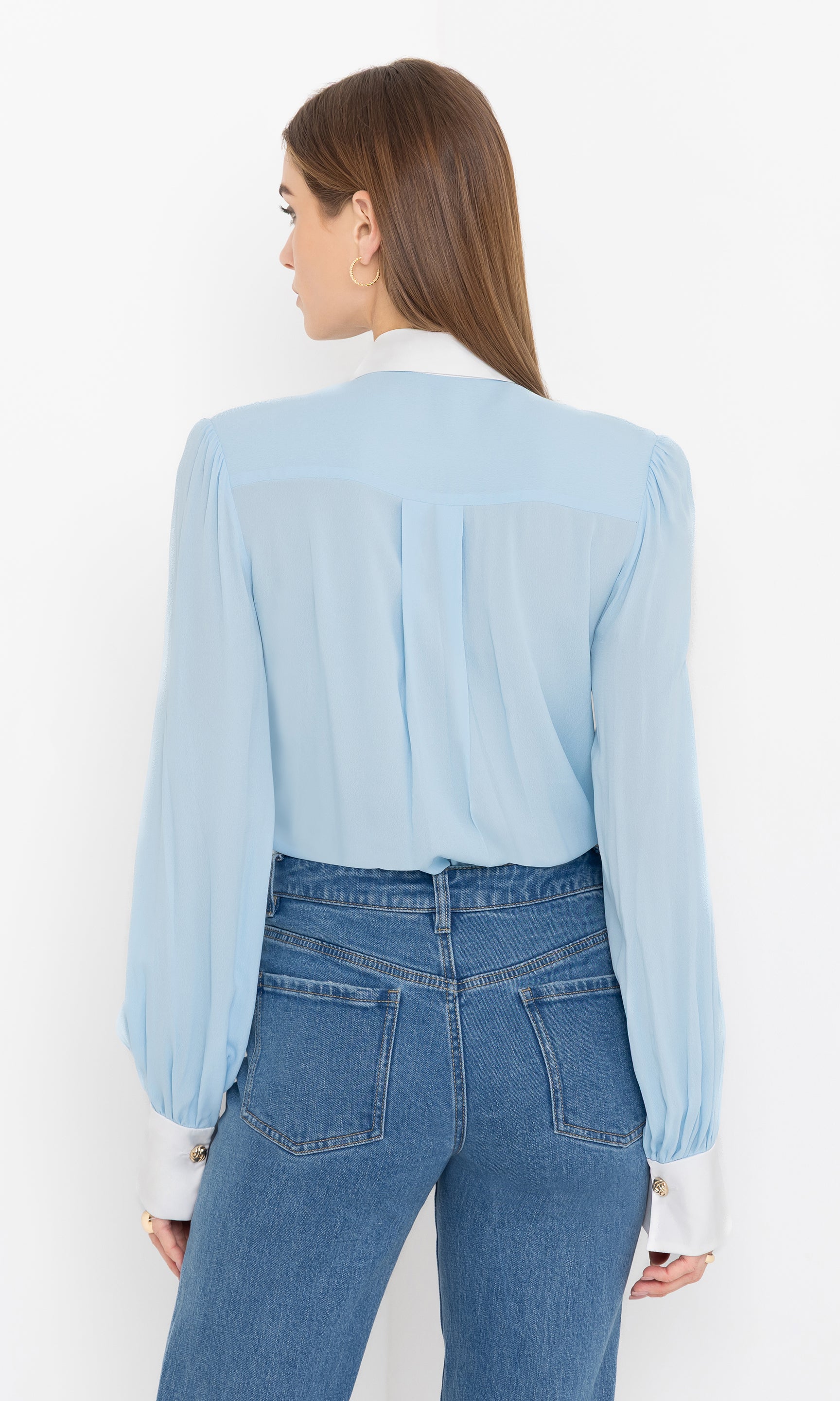 Rear view highlighting the blouse’s tailored fit and smooth drape.