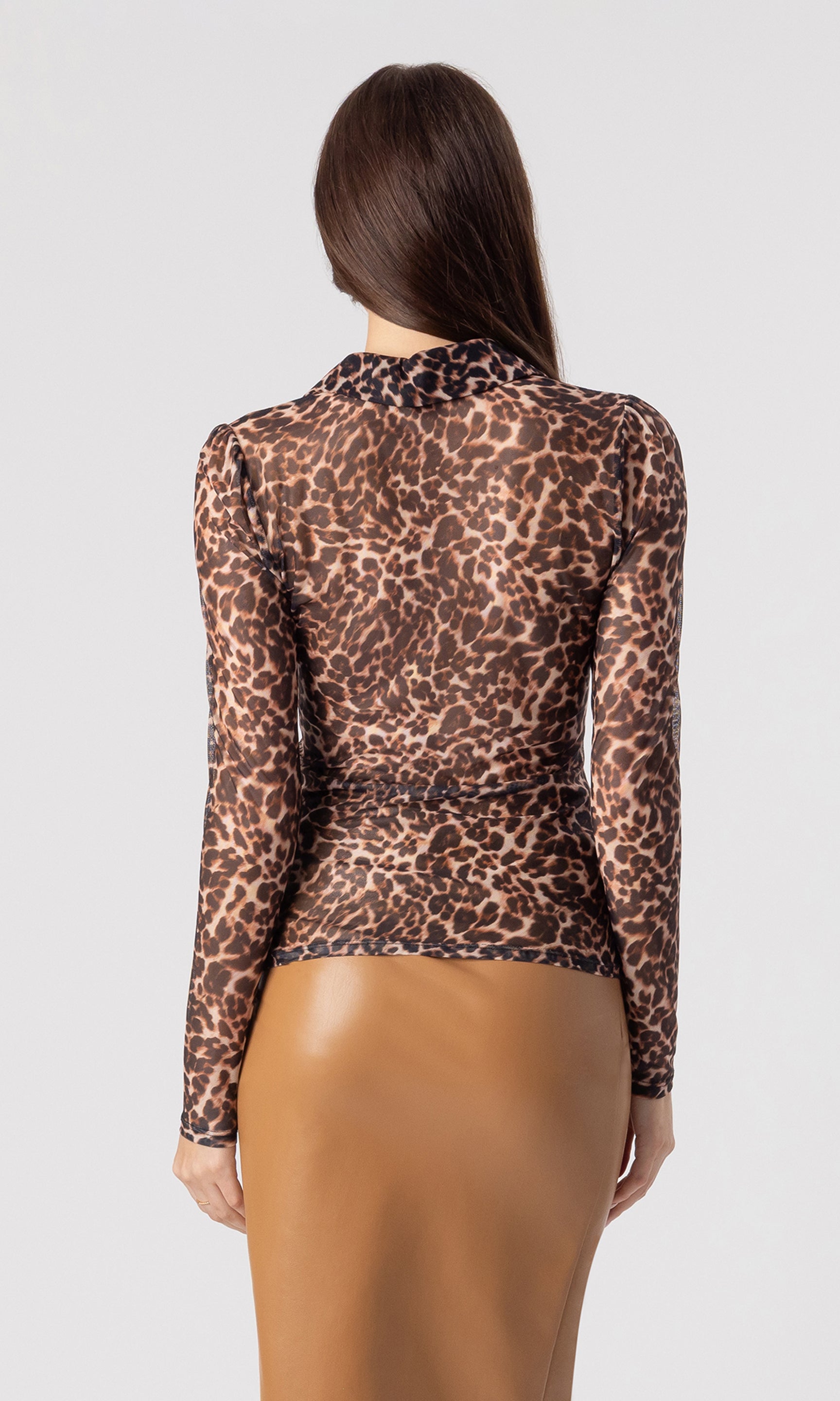 back image of model wearing the Dominique mesh top in a leopard print paired with a brown vegan leather skirt