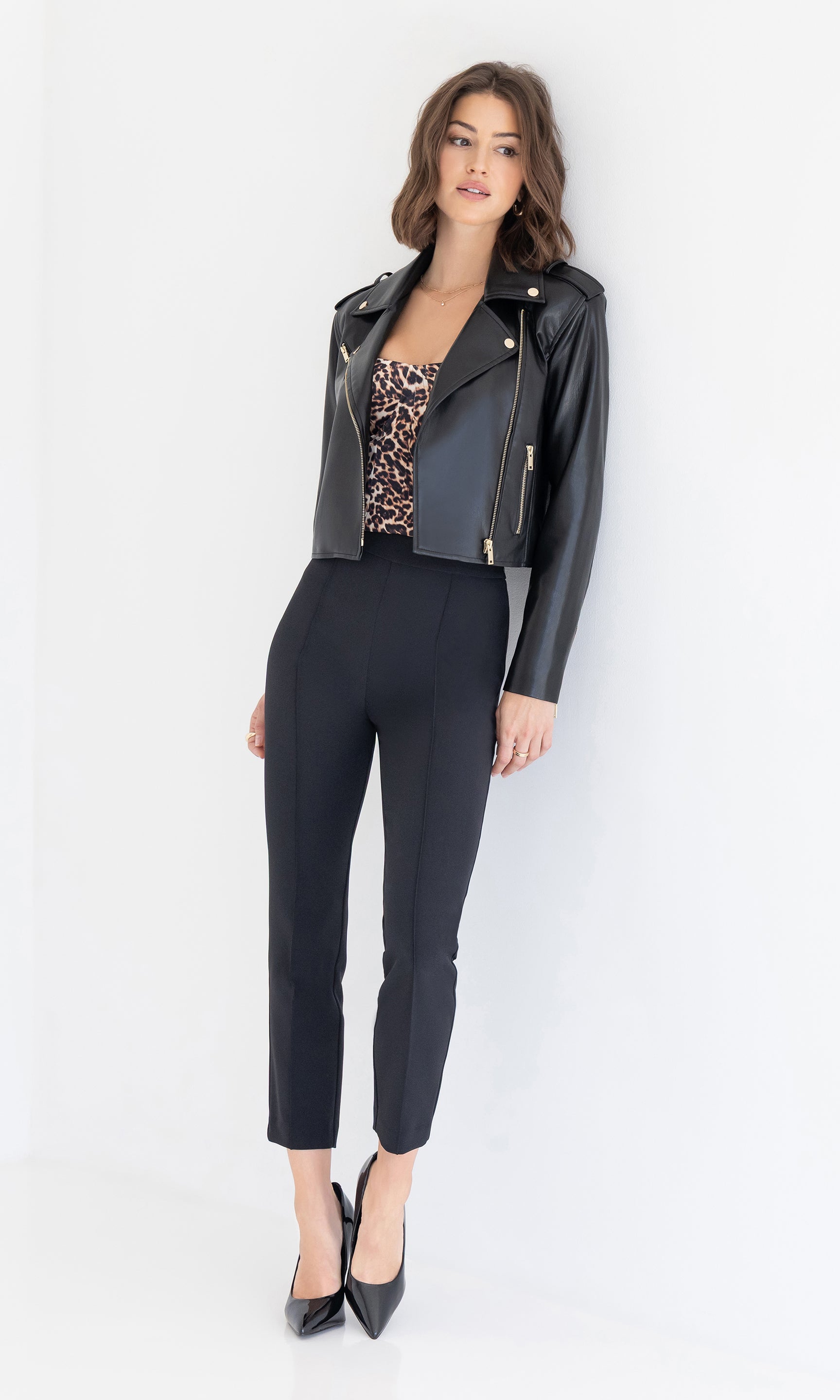 Full body view of the Cosita Vegan Leather Jacket layered over a leopard-print top, paired with black slim-fit pants and heels.