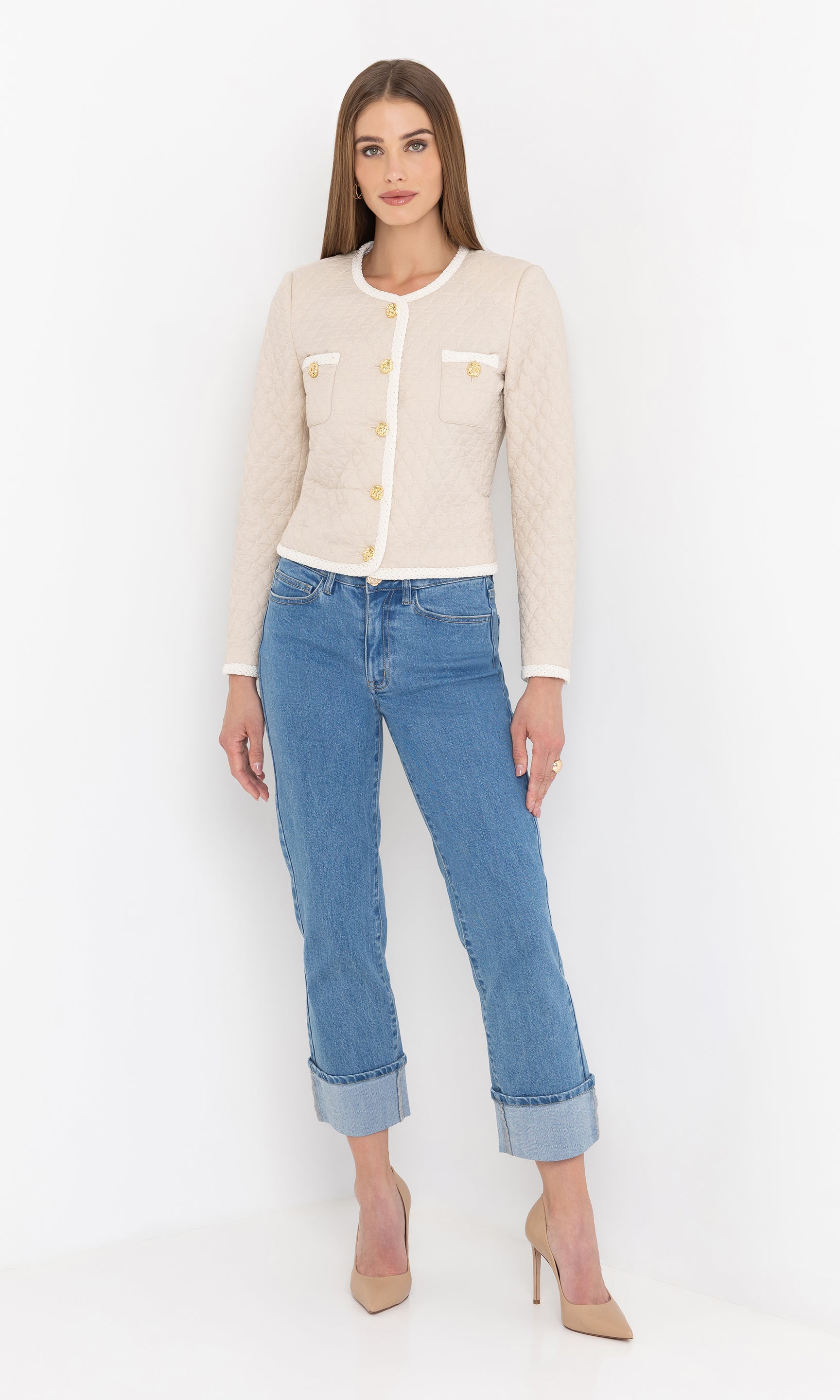 Standing in a relaxed stance, the model wears the cream Everie Quilted Jacket with sleeves slightly pushed up.