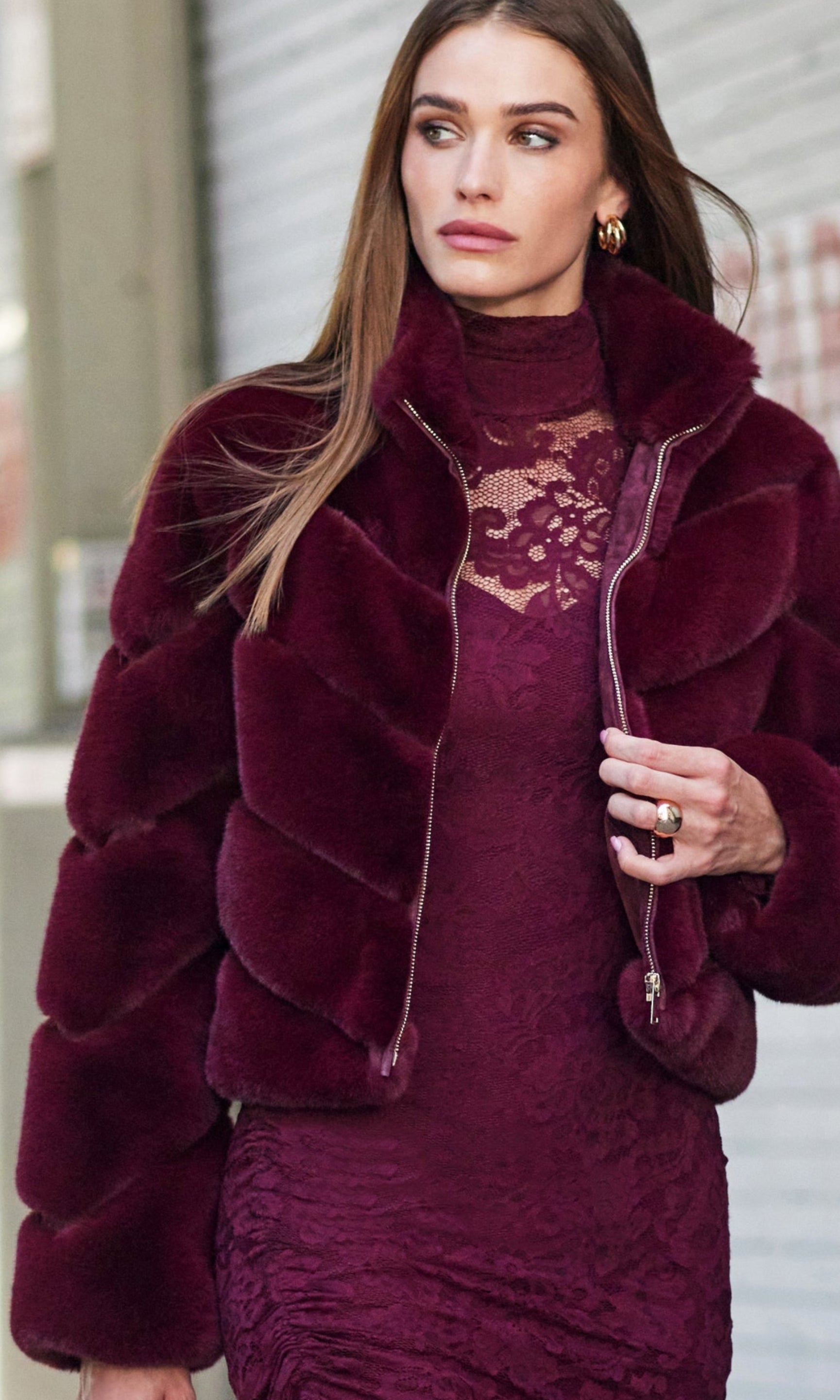 Woman wearing a burgundy outfit with a matching jacket in an urban setting