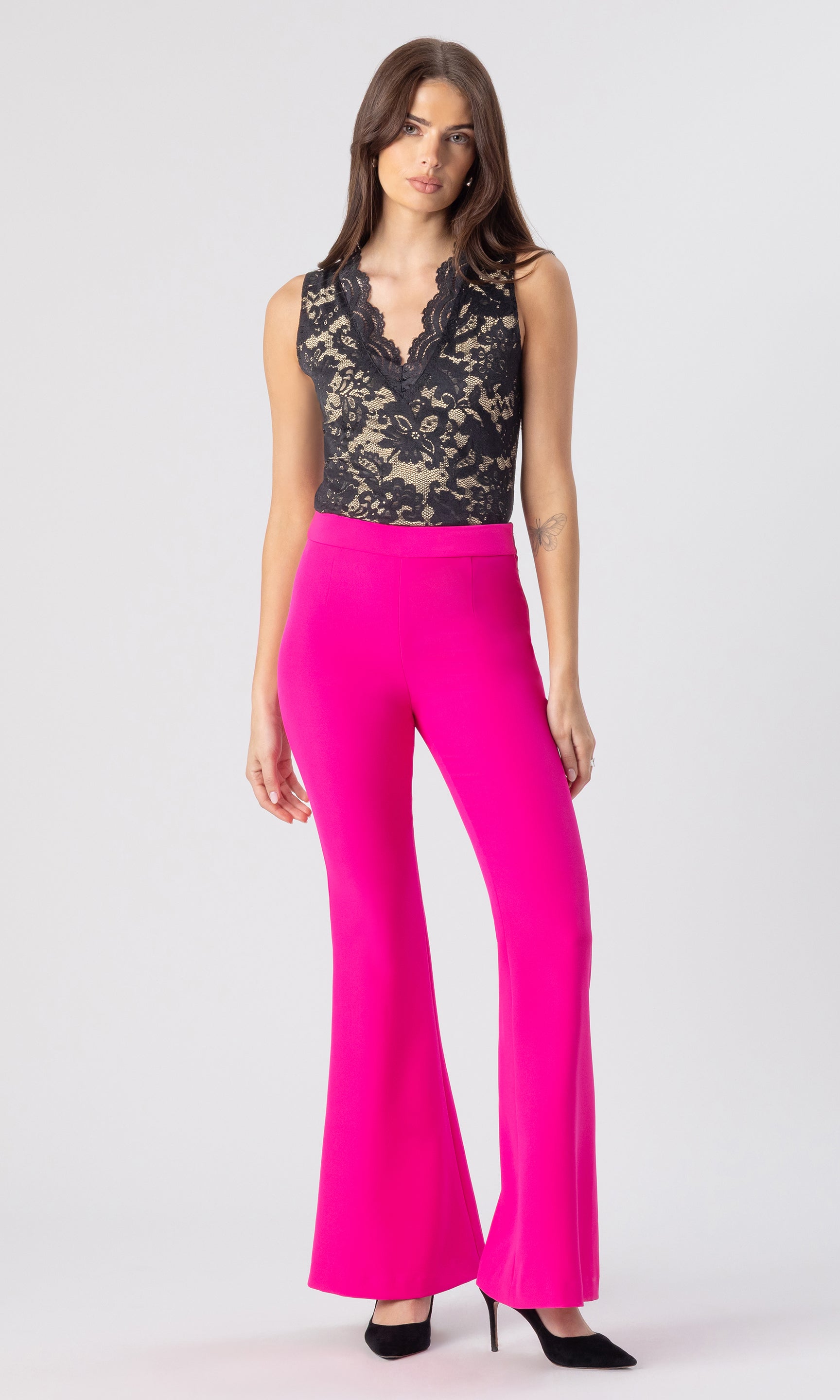 full body image of model wearing the Wesley crepe pants in hot pink, paired with a black/beige lace top and black heels