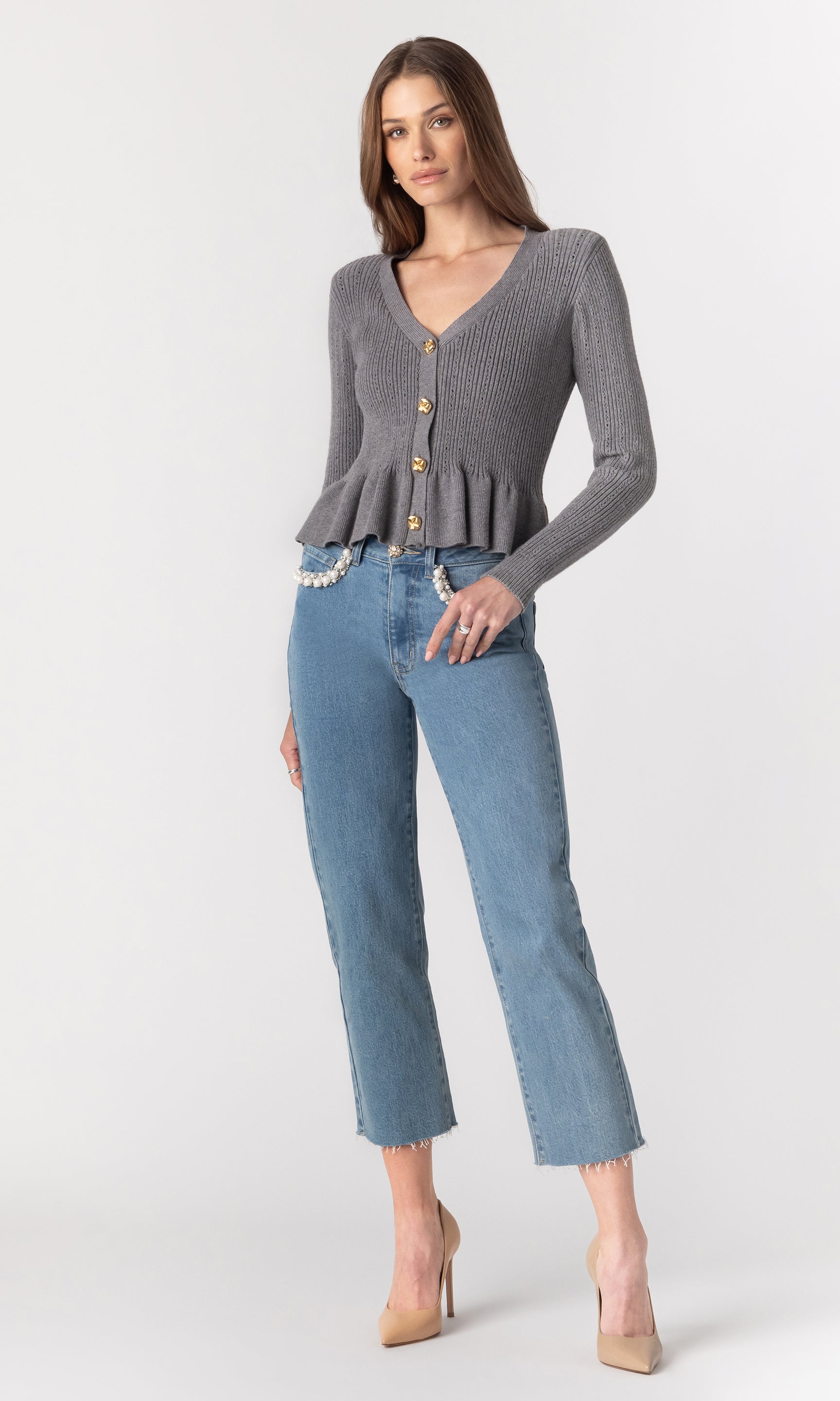 full body image of model wearing the Lirio Pointelle Cardigan in a grey color paired with blue jeans and beige heels