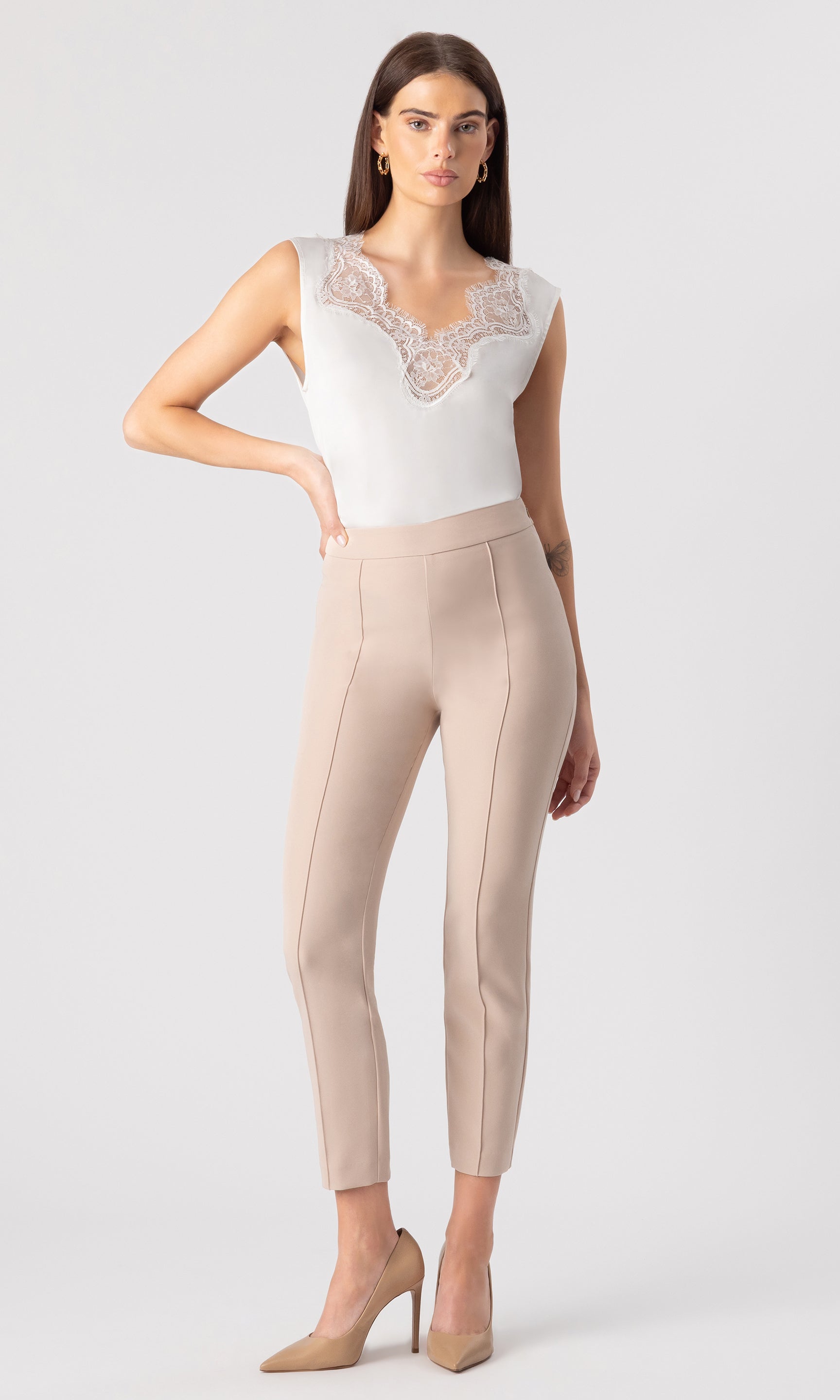fully body image of model wearing the Lonny Crepe Pants in latter paired with a white top and beige heels