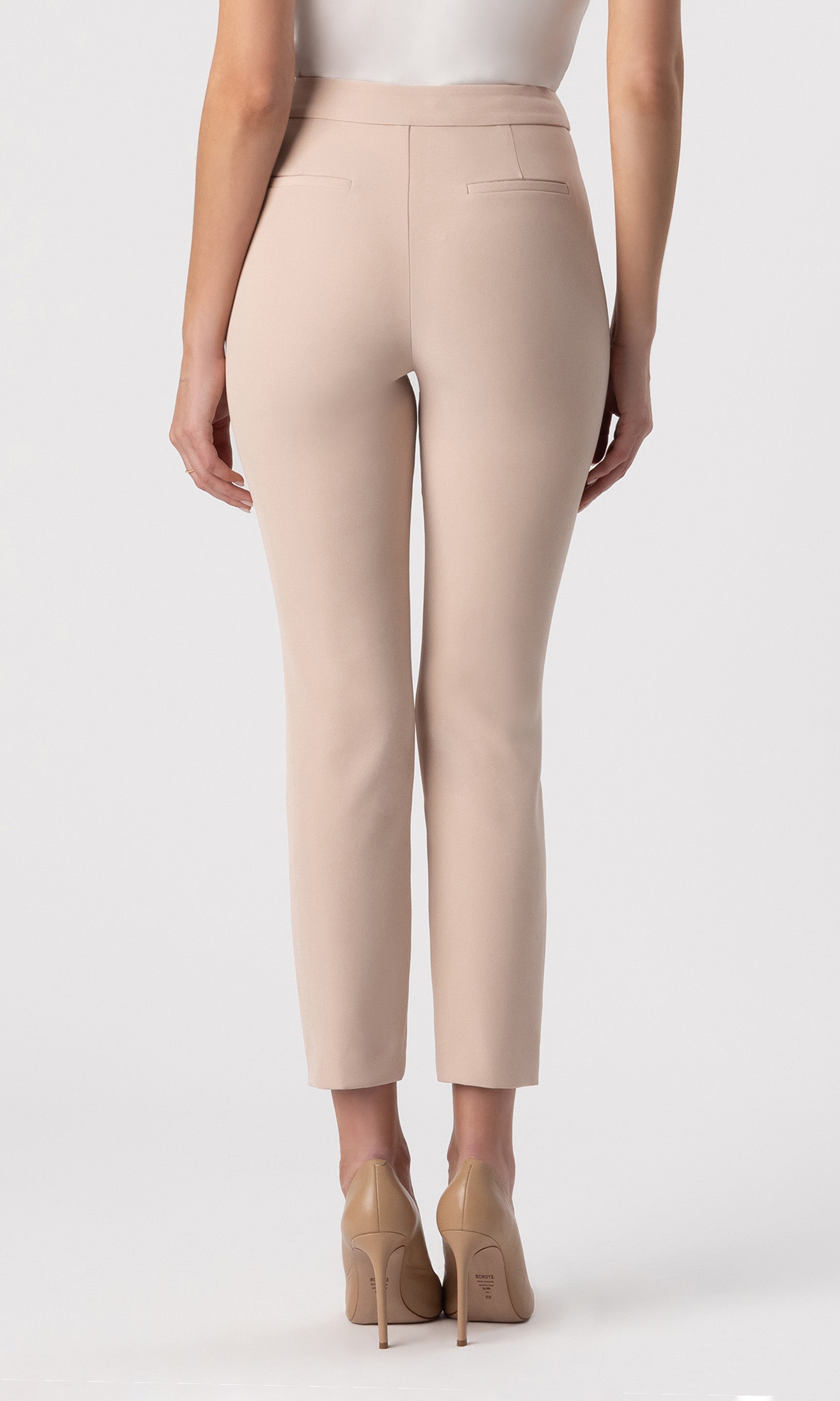 cropped back view image of model wearing the Lonny Crepe Pants in latter paired with a white top and beige heels
