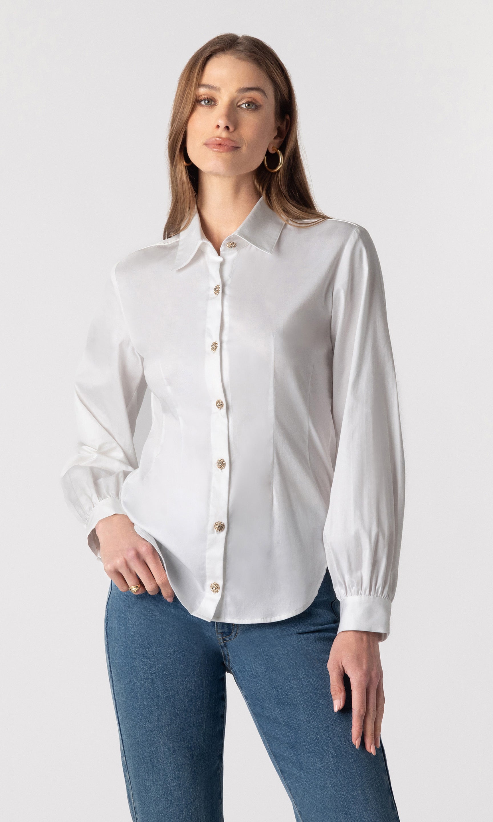 image of model wearing the Lonny button-down blouse with her hand in her pocket, paired with dark blue jeans