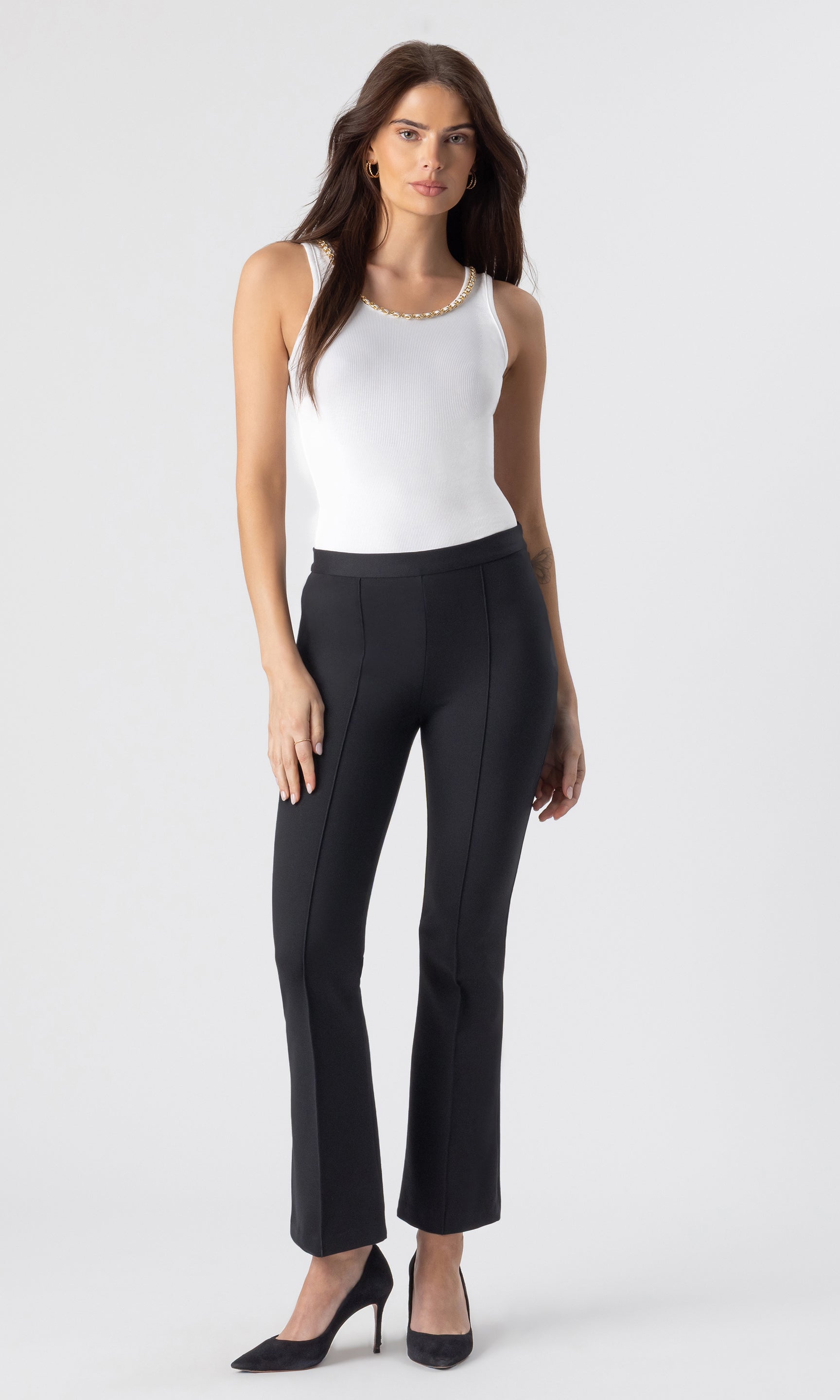 full body image of model wearing the Mabel tank in white with a chain embellished neckline paired the Fay Ponte black leggings and black heels