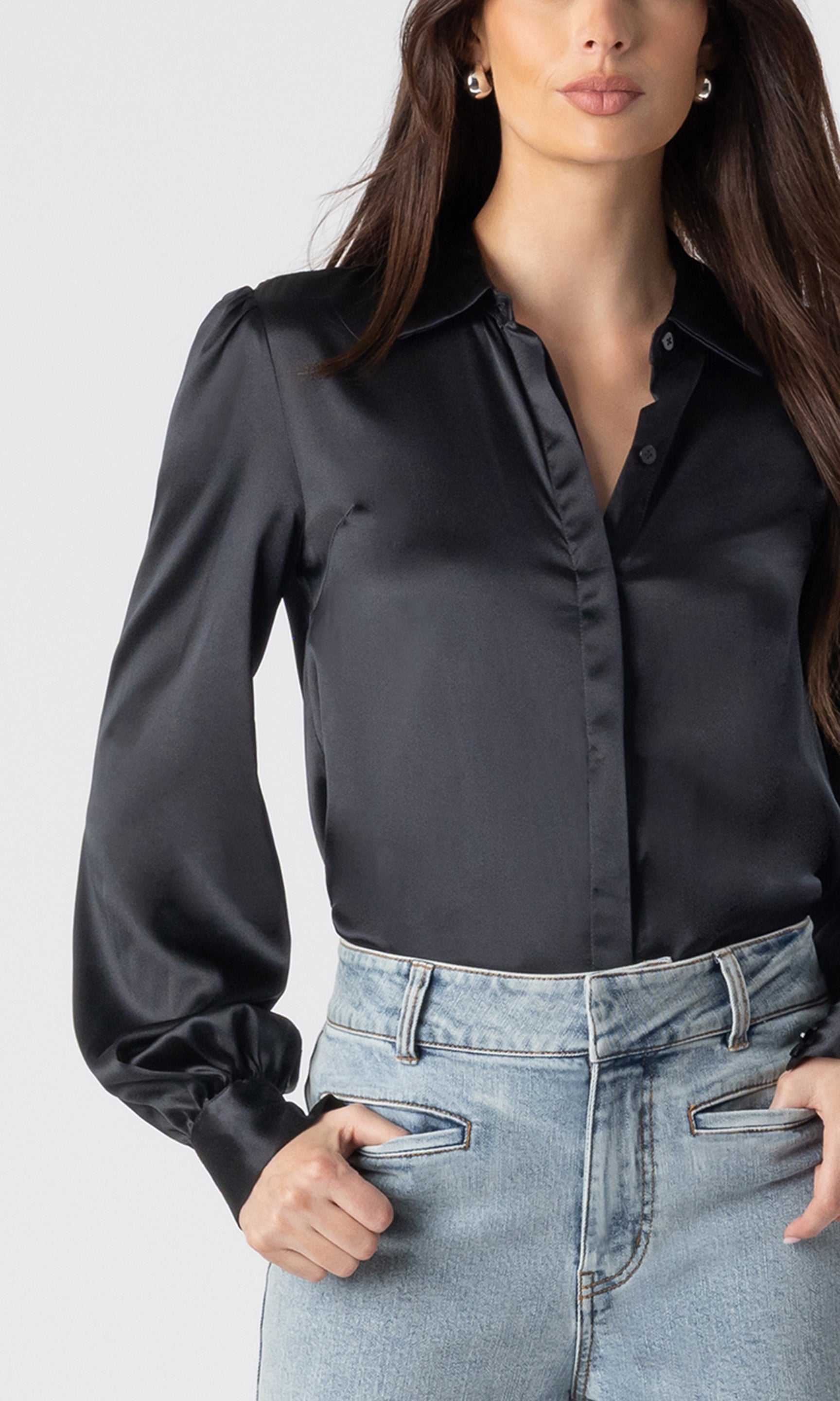 zoomed in image of model wearing the Maxwell blouse in black tucked into light blue jeans, showcasing the beautiful silk fabric