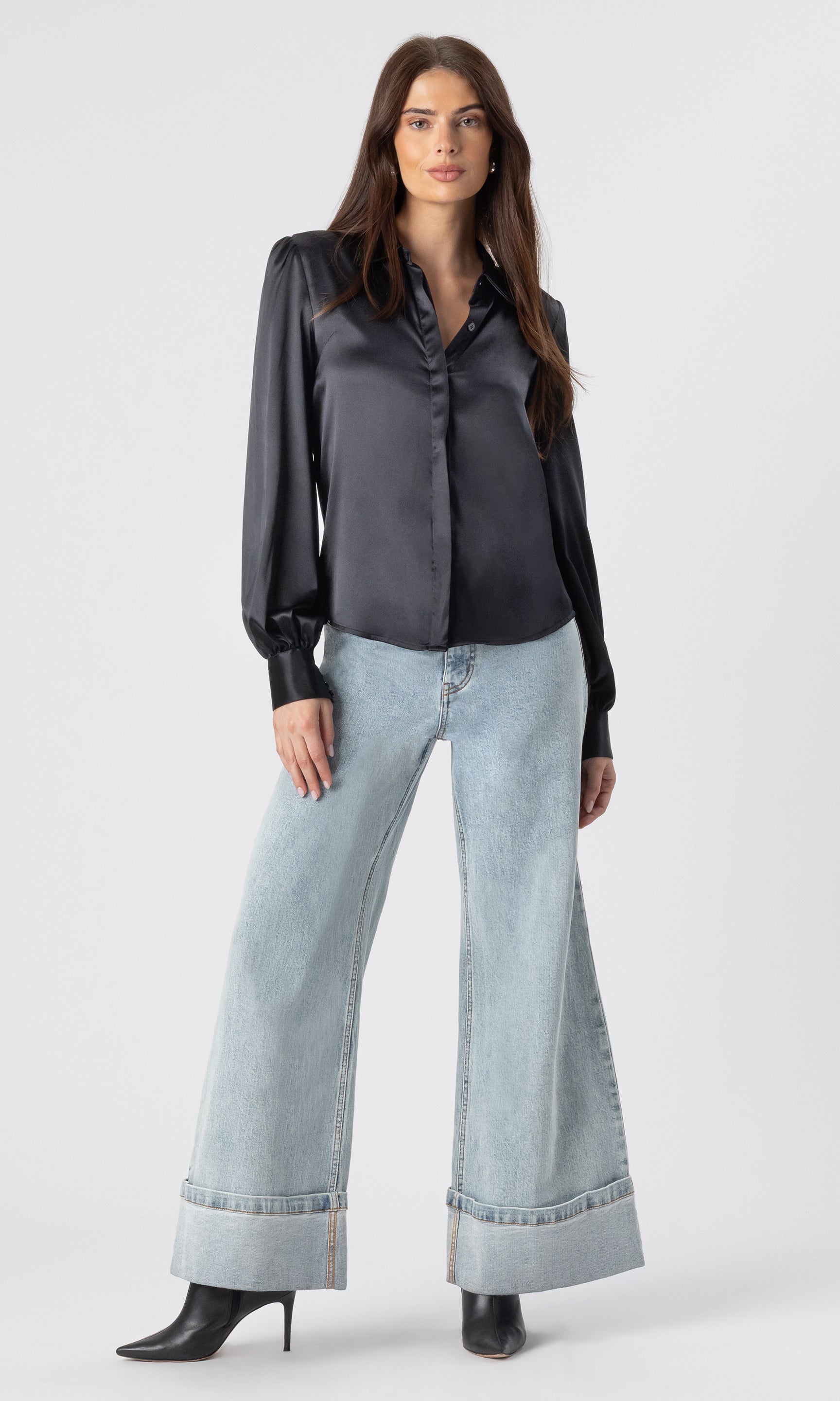 full body image of model wearing the Maxwell blouse in black paired with light blue jeans and heeled black booties