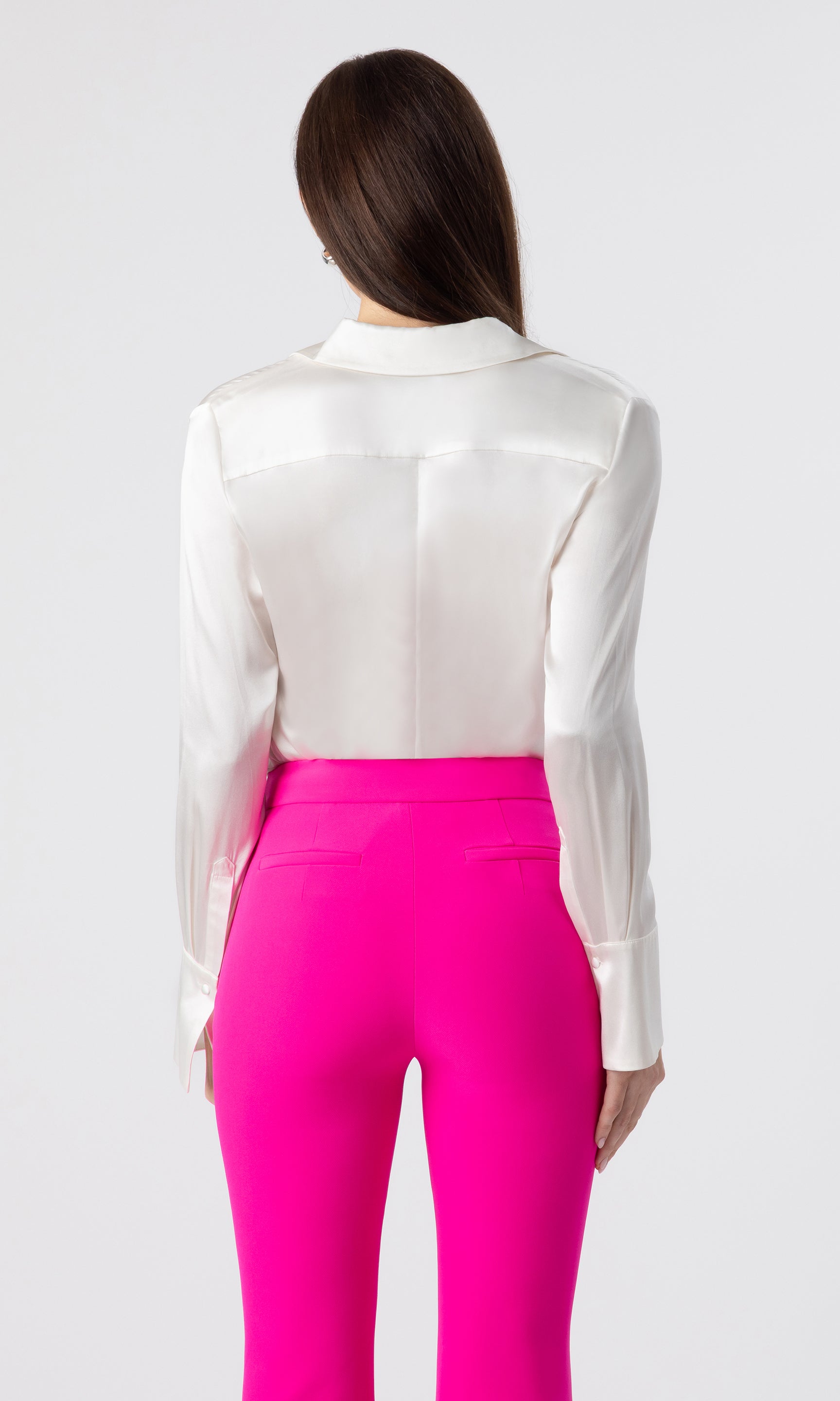 back view image of model wearing the Maxwell blouse in white paired with hot pink crepe pants