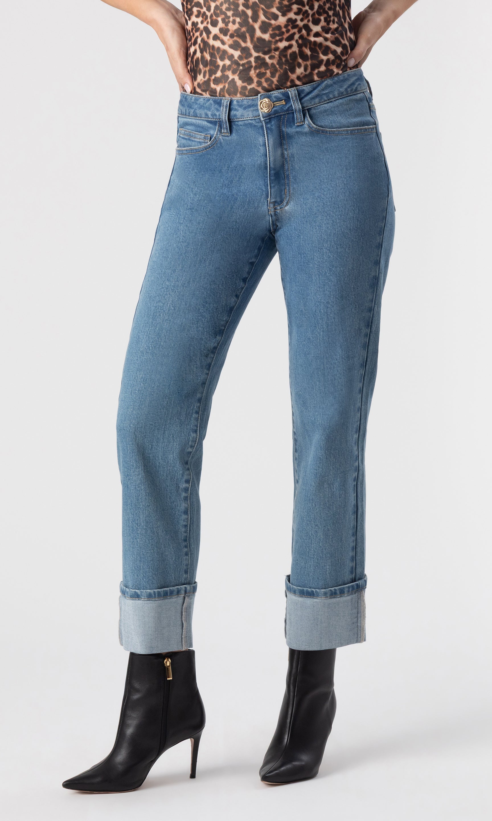 cropped front view image of model wearing the Rylan Denim Jeans with folded cuffed legs, paired with a leopard print top and black heeled booties