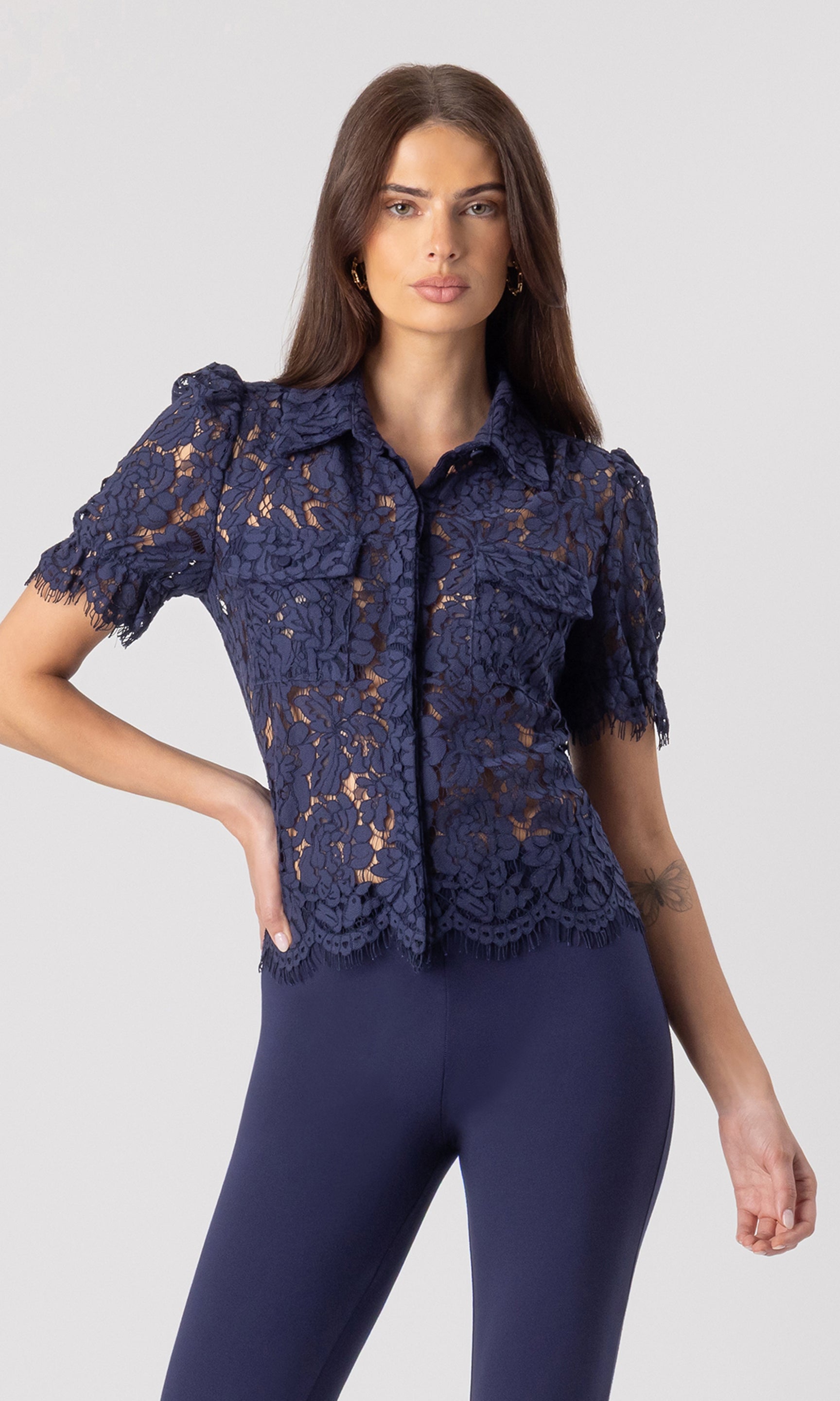 image of model posing with her hand on her hip wearing the Mina lace shirt in navy paired with matching navy leggings