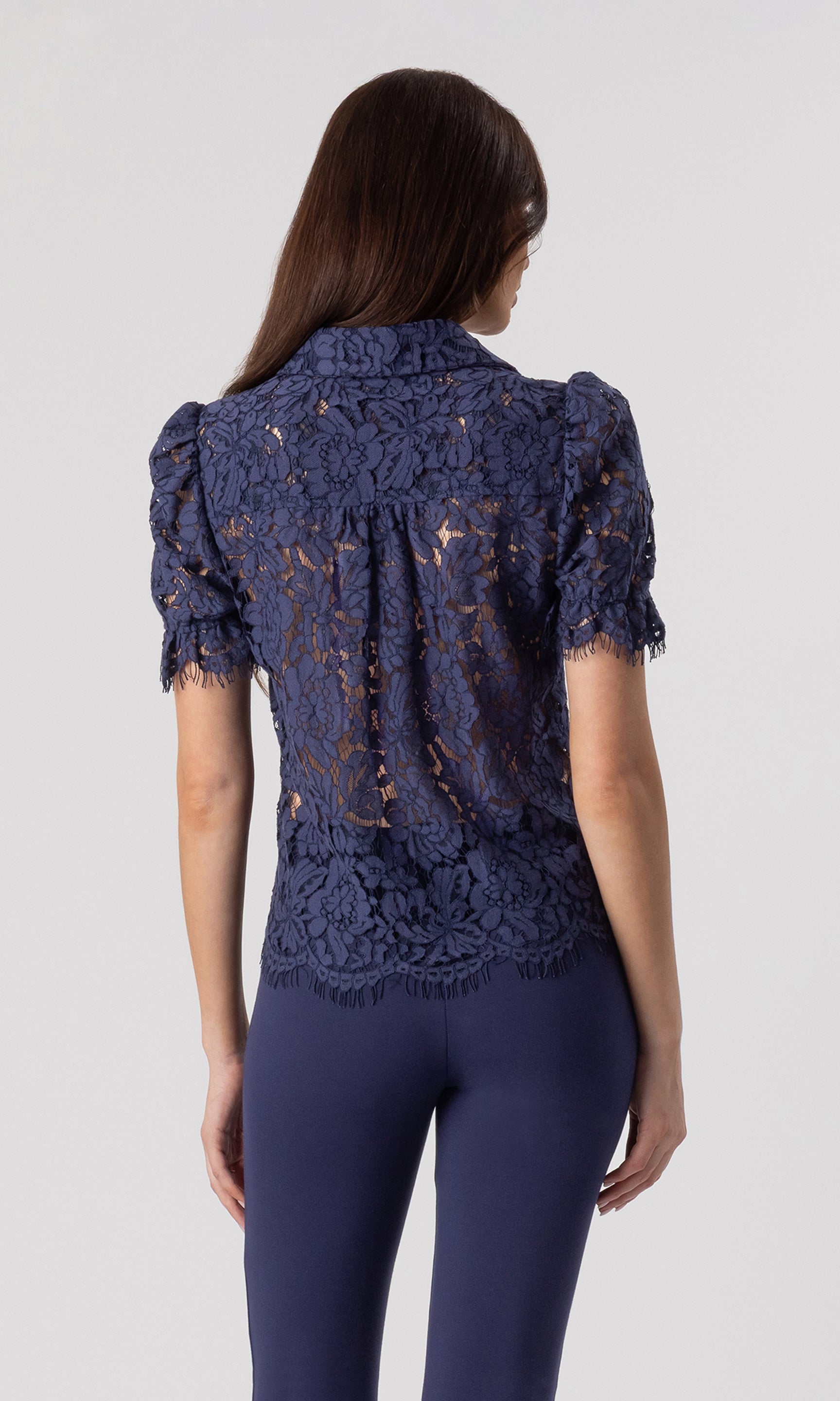 back view image of model wearing the Mina lace shirt in navy paired with matching navy leggings