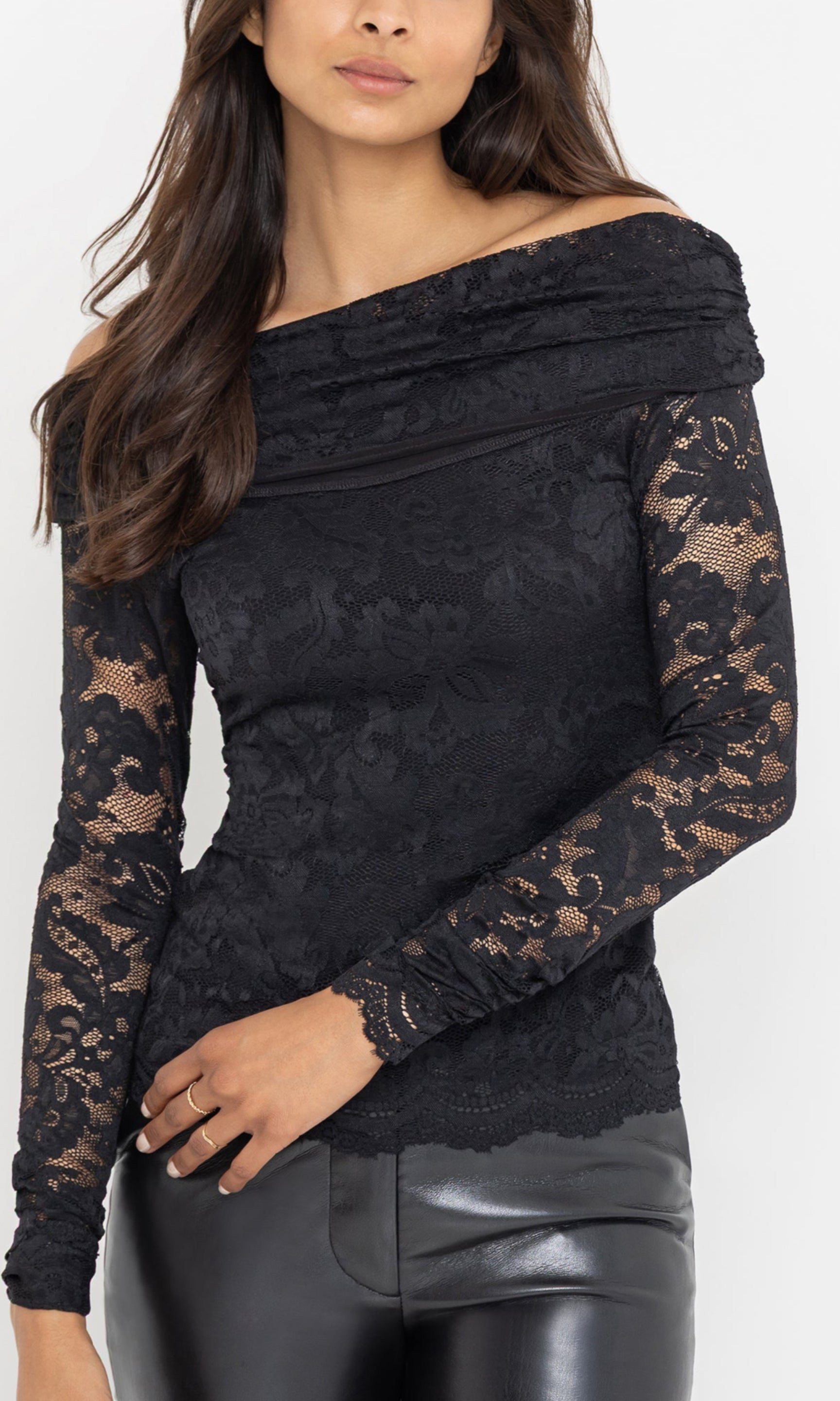 The model stands in a three-quarter front view wearing the Romeo Lace Top in black, highlighting the textured lace bodice and sheer sleeves.