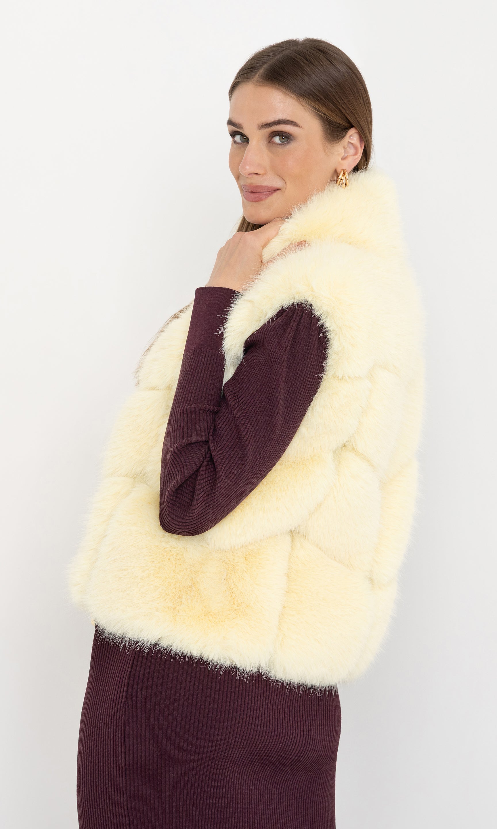 Side angled view of Rosario Faux Fur Vest in cream, showcasing its flattering fit and cozy design.