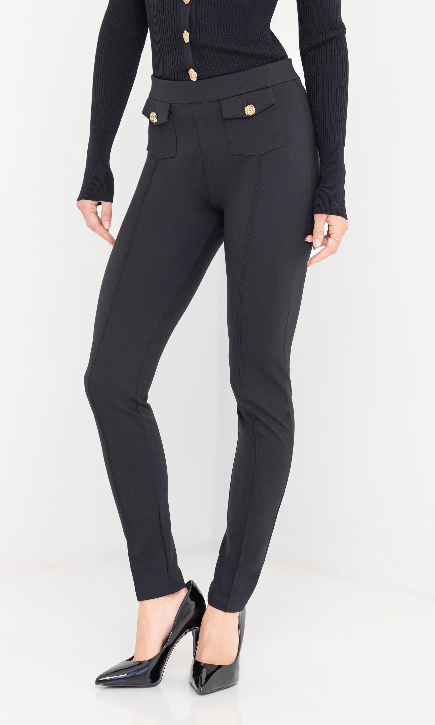 Side view of Roy Ponte Leggings in black, highlighting the slim fit and gold button detailing at the waist.