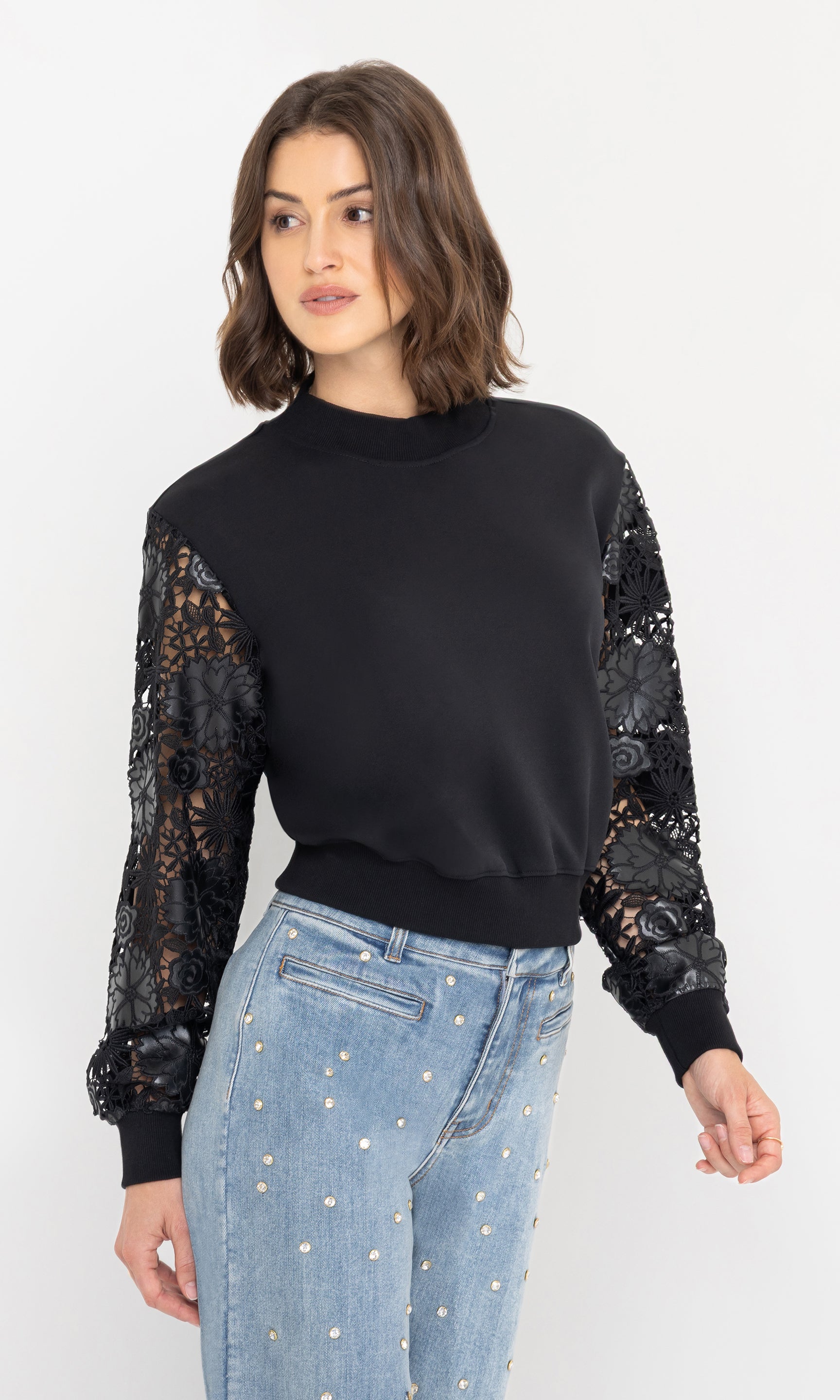 Side view highlighting the intricate guipure lace sleeve detail on the theron guipure combo sleeve sweatshirt, paired with light-wash jeans.