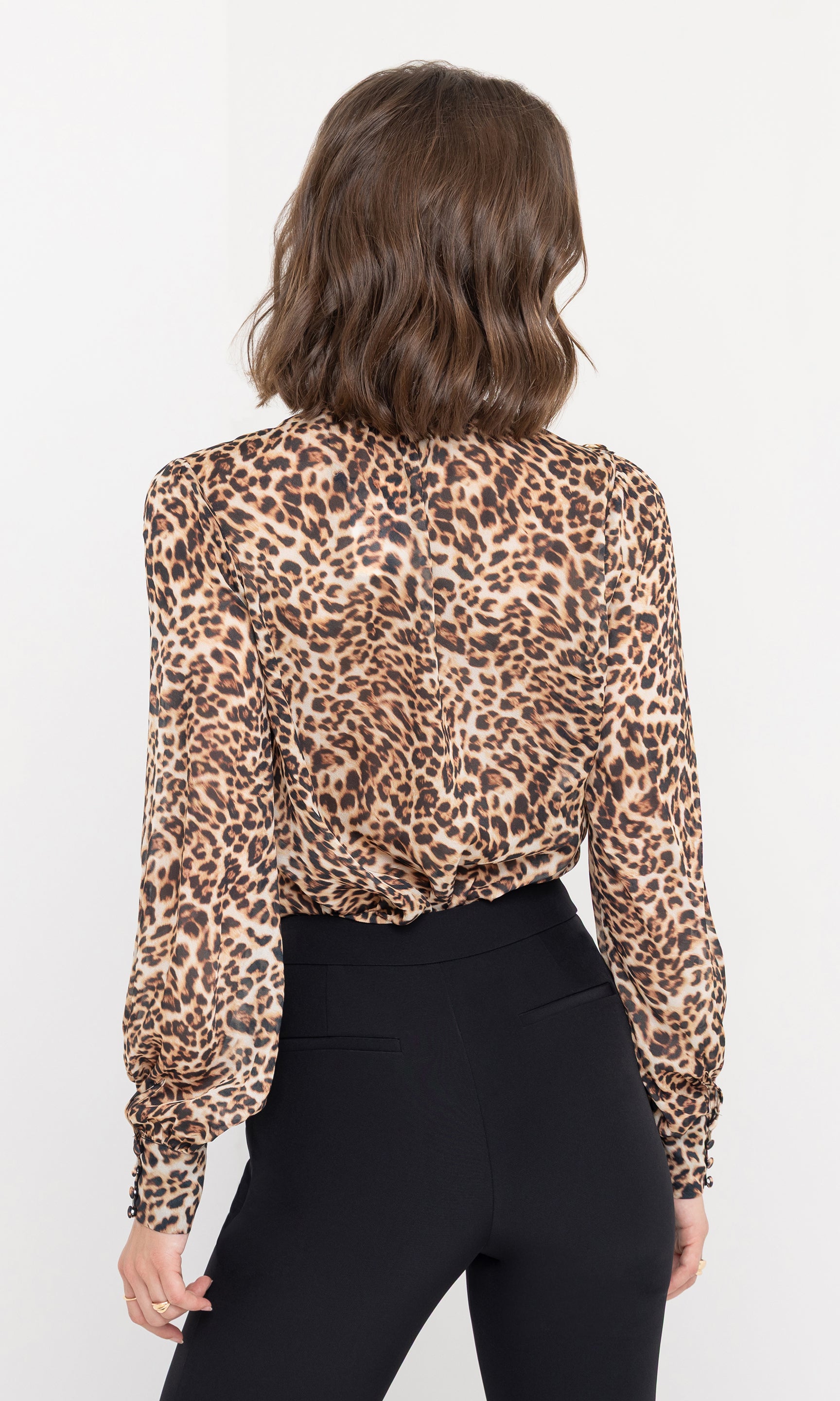 Rear view of the Veralli Leo Blouse, showing its flowing cut and continuous leopard print pattern.